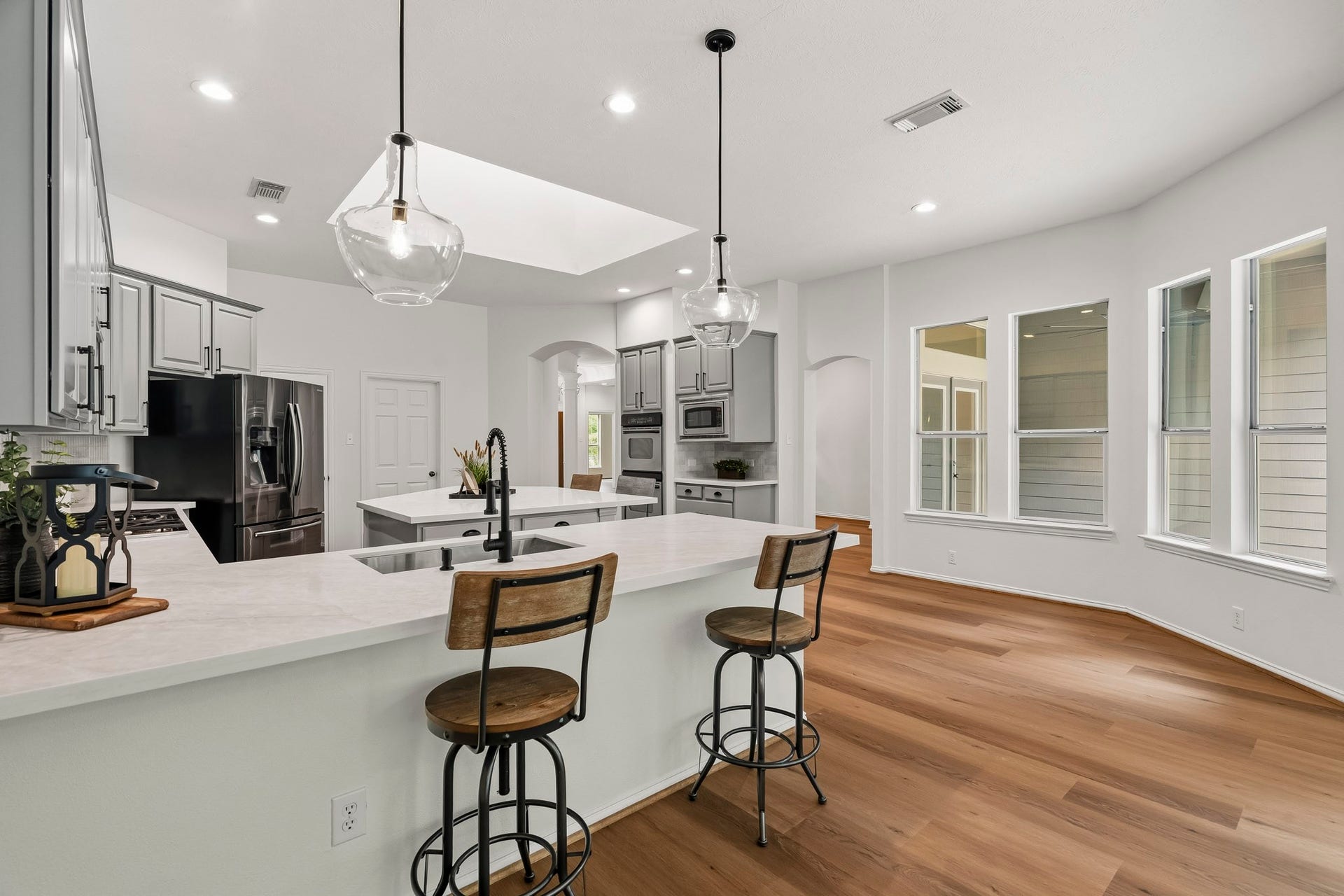 5202 Bessies Creek Trace, Fulshear, TX 77441 A look back at the Kitchen shows the convenient layout and another glimpse at the Island. Overhead, a large skylight floods the space with natural light, accentuating the sophisticated finishes and reinforcing the seamless blend of beauty, practicality, and contemporary elegance.