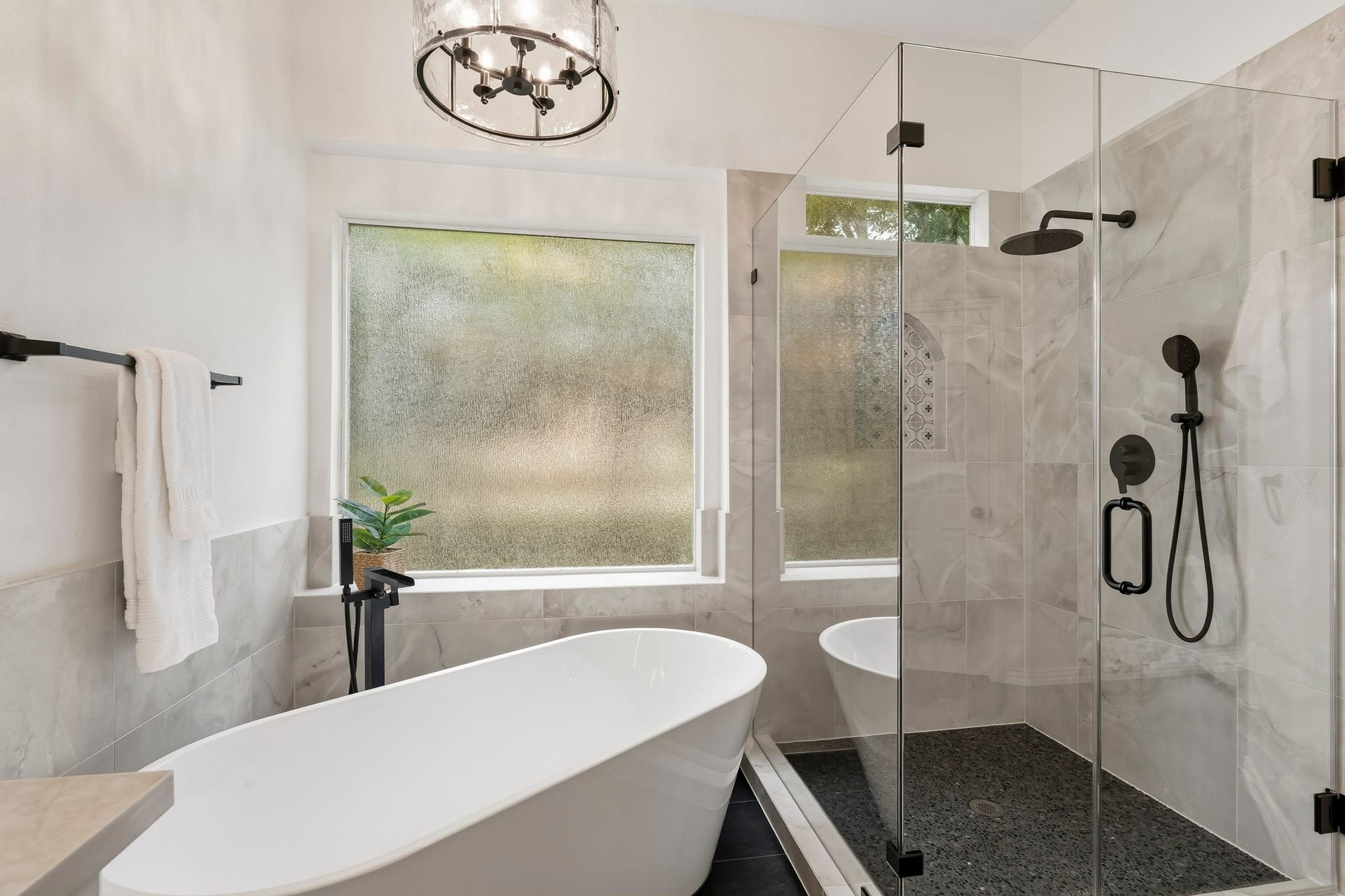 5202 Bessies Creek Trace, Fulshear, TX 77441 A stunning new frameless glass shower serves as the centerpiece of the Primary Bath, showcasing marble inspired tile, dual shower heads, and an elegant arched shampoo niche that adds a touch of architectural charm. A freestanding soaker tub, with a sleek floor-mounted faucet, creates a spa-inspired focal point, offering the perfect place to unwind and recharge in style.