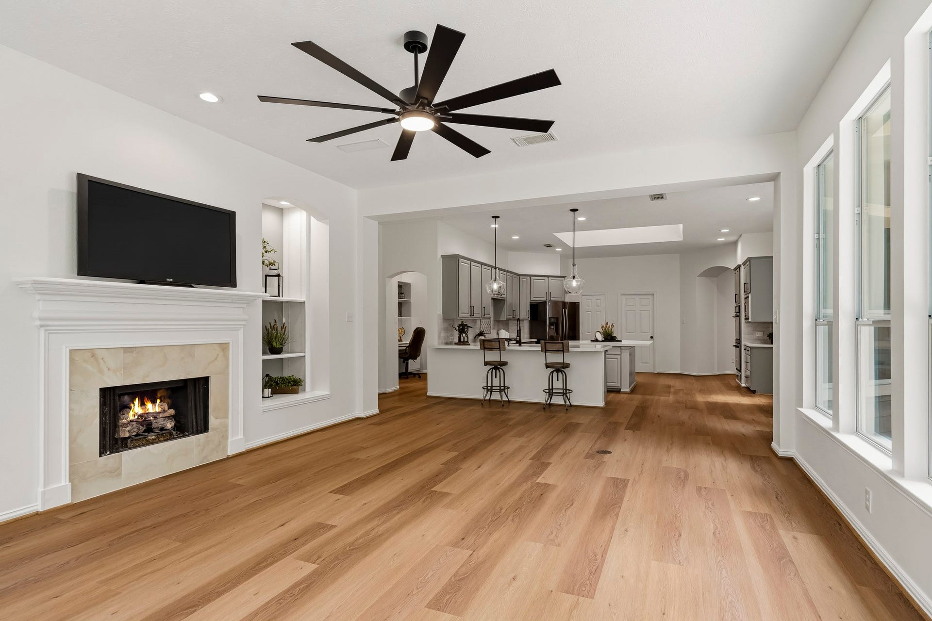 5202 Bessies Creek Trace, Fulshear, TX 77441 Anchoring the space is a gas fireplace updated with a sophisticated marble-inspired tile surround, adding a fresh layer of elegance and timeless appeal to this inviting gathering space.