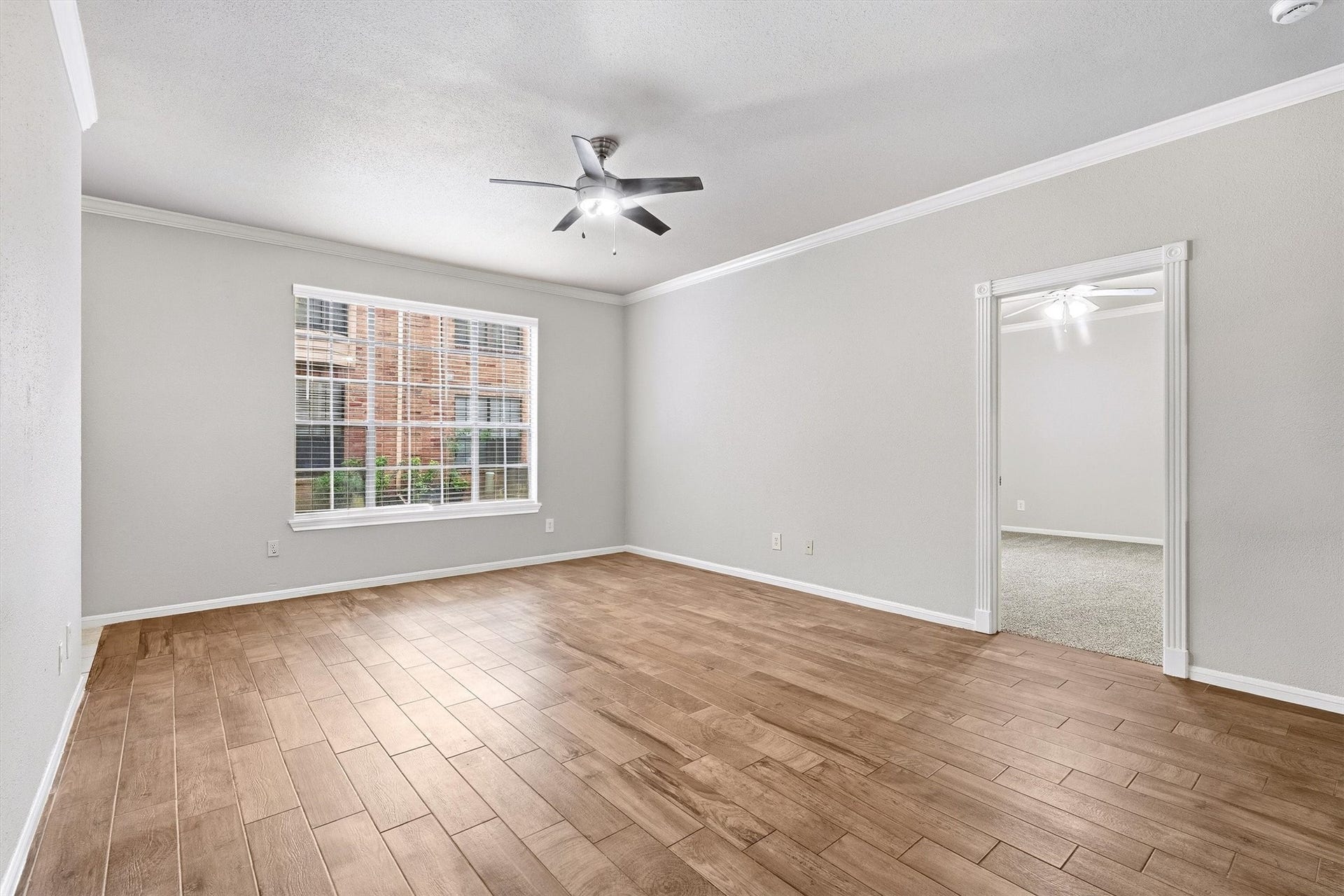 Alternate view of the living room highlighting its generous proportions and adjoining bedroom access.