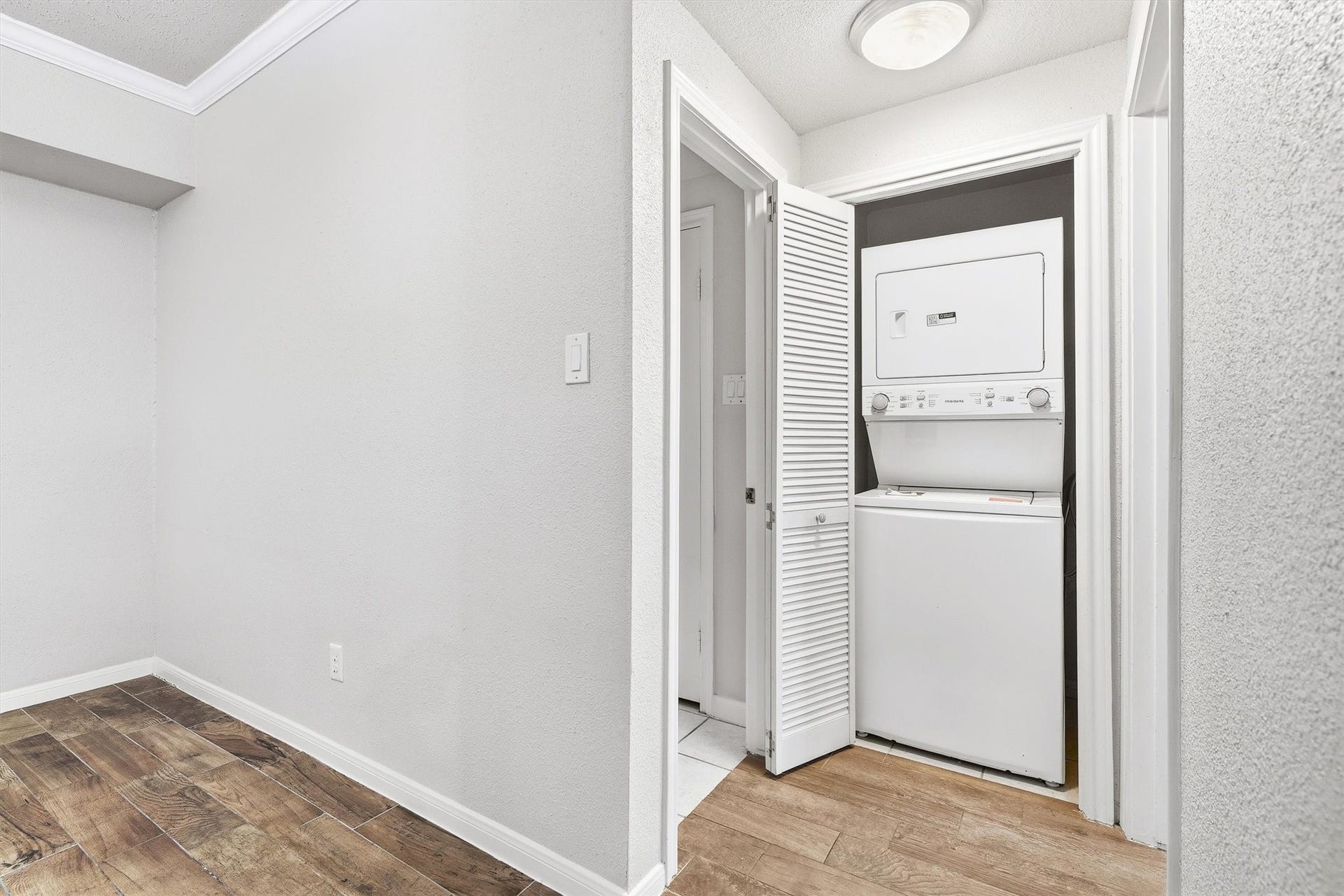 In-unit laundry closet with stacked washer and dryer for added everyday convenience.