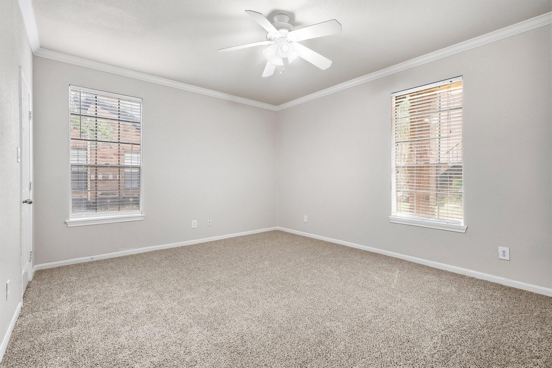 Additional view of the spacious bedroom with neutral finishes and convenient closet access.