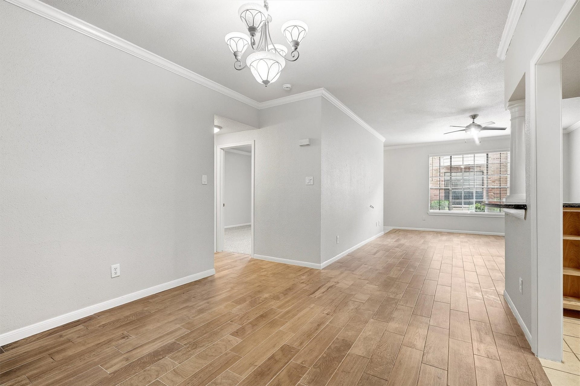 Spacious main living area with neutral finishes, wood-look flooring, and seamless connection to the kitchen.