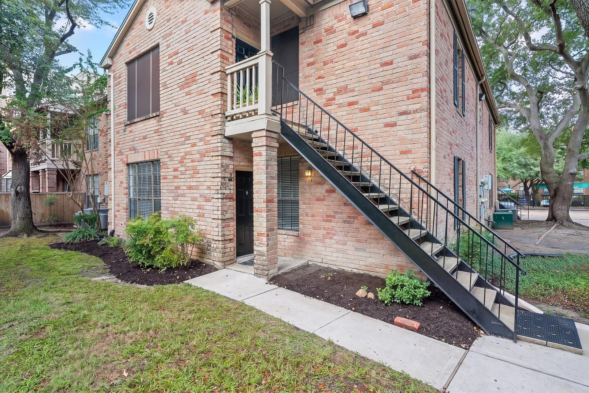 Closer look at the building exterior with private entry access and stairway leading to the upper residence.