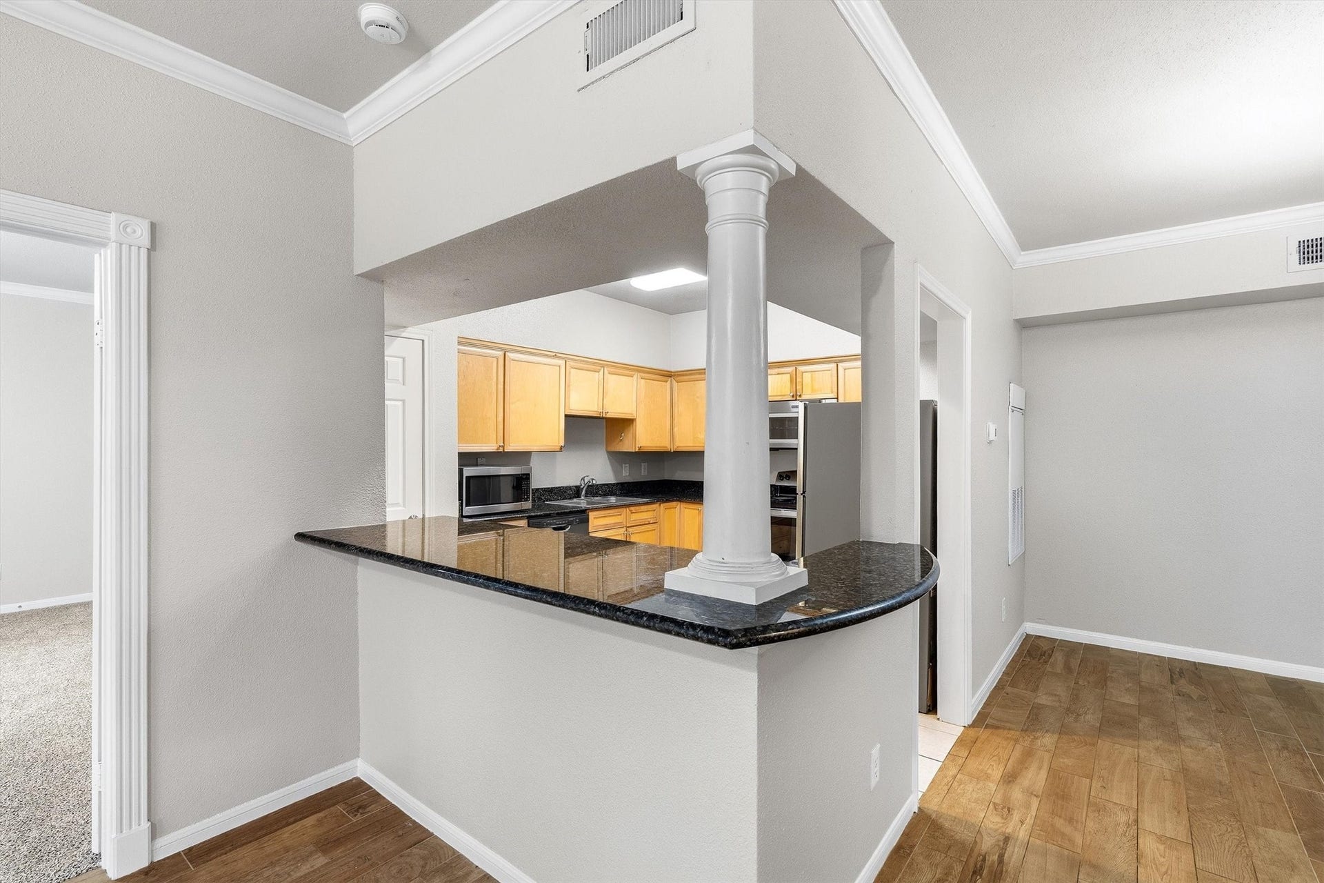 Generously sized bedroom with carpet, crown molding, ceiling fan, and windows on two sides for natural light.