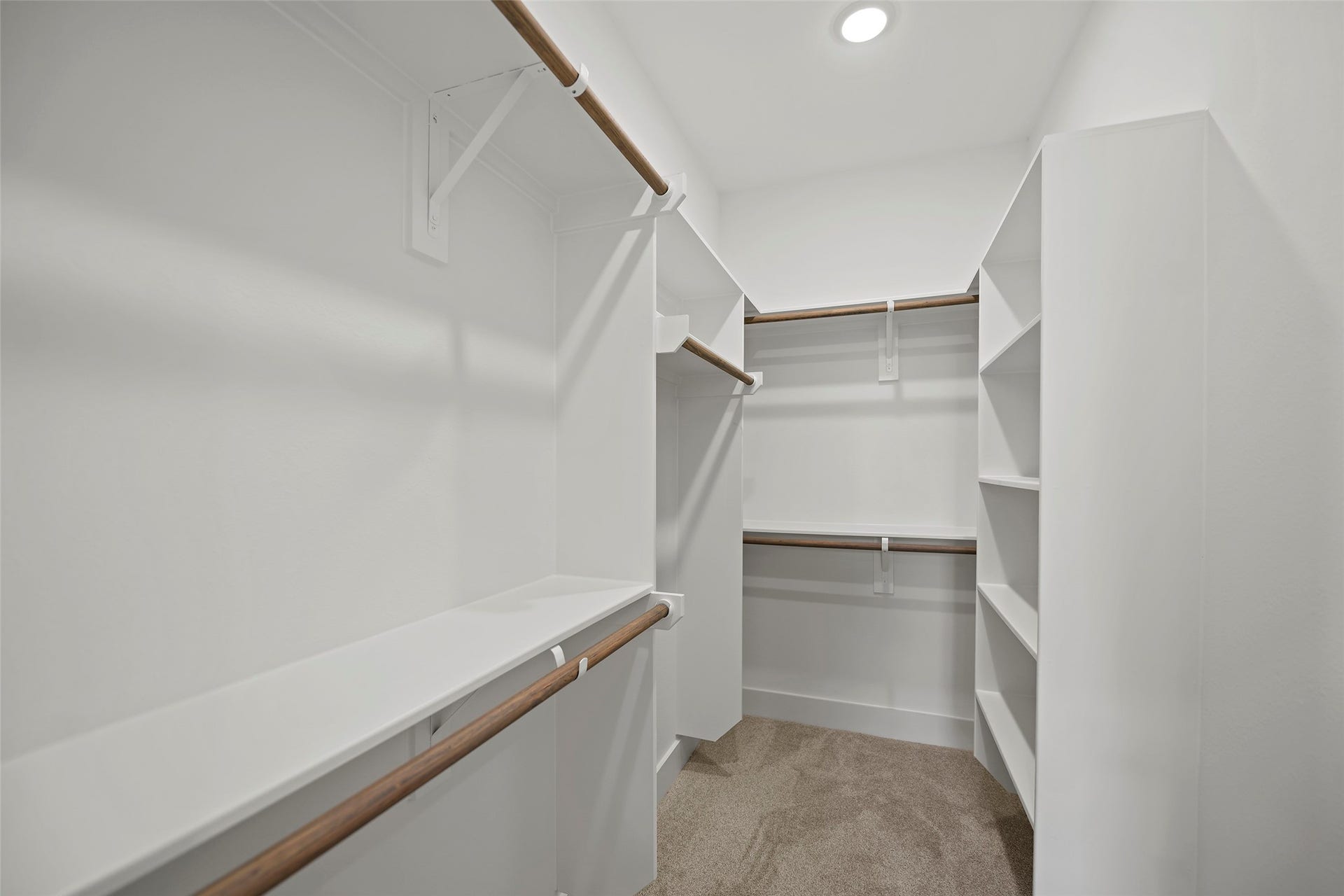 870 W Little York Road, #A, Houston, TX 77091 A spacious walk-in closet featuring multiple hanging rods, open shelving, and bright lighting, ideal for ample storage and organization.