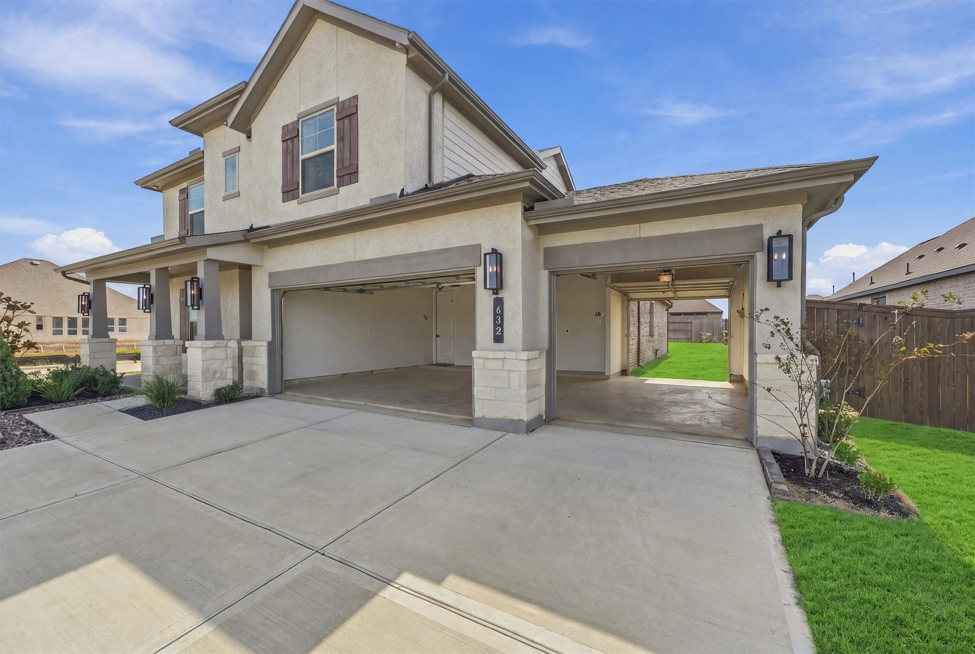 Three bays, including a drive-through bay with a rear door to the backyard for mowers, toys, or a workshop.