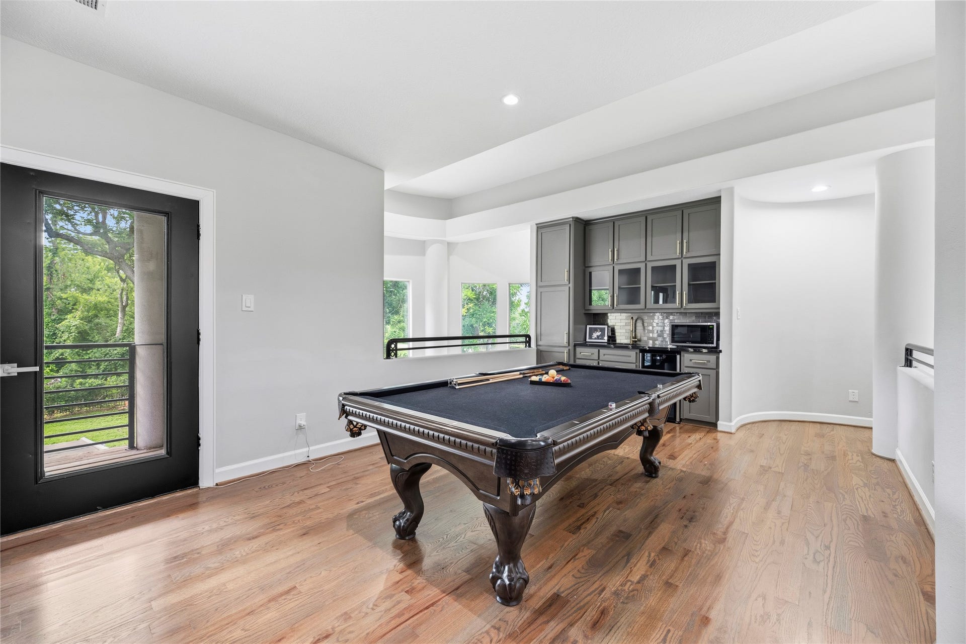 23 Westpoint Drive, Missouri City, TX 77459 Expansive game room with custom wet bar and balcony access, ideal for family fun and hosting guests.