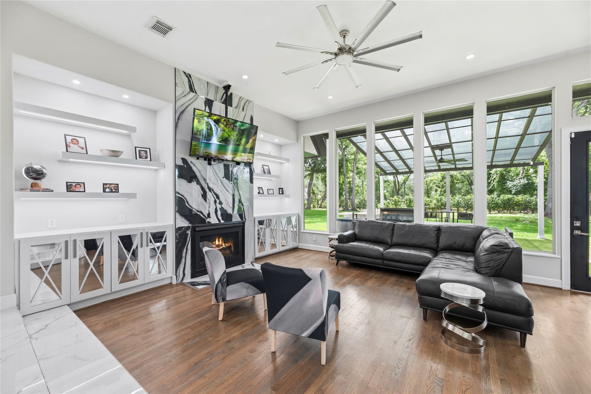 23 Westpoint Drive, Missouri City, TX 77459 Inviting family room with a dramatic fireplace wall, custom built-ins, and stunning backyard views.