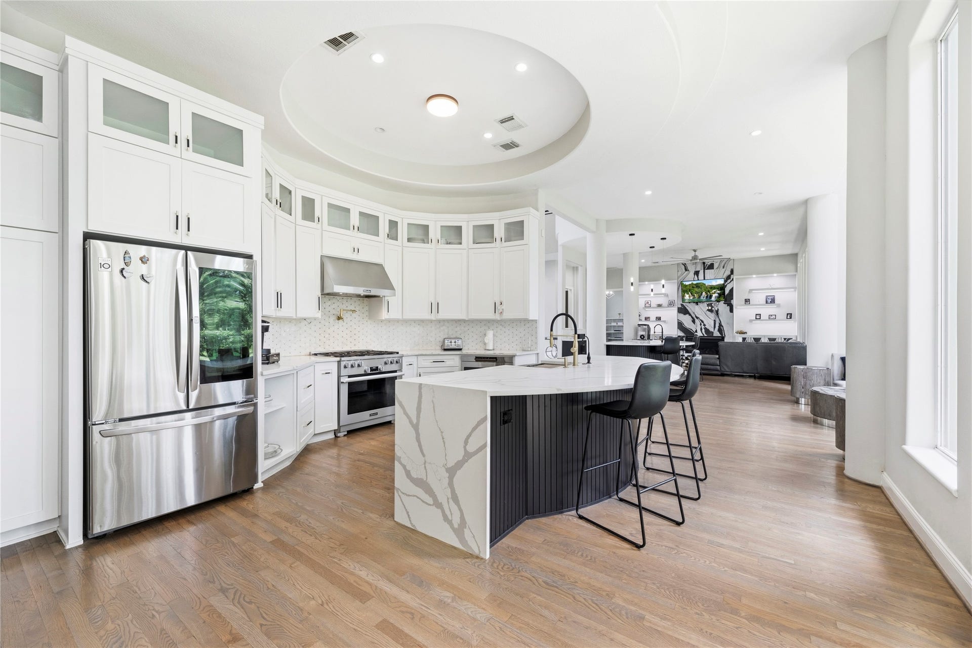 23 Westpoint Drive, Missouri City, TX 77459 Designer chefs kitchen featuring a dramatic quartz waterfall island, custom cabinetry, premium appliances.