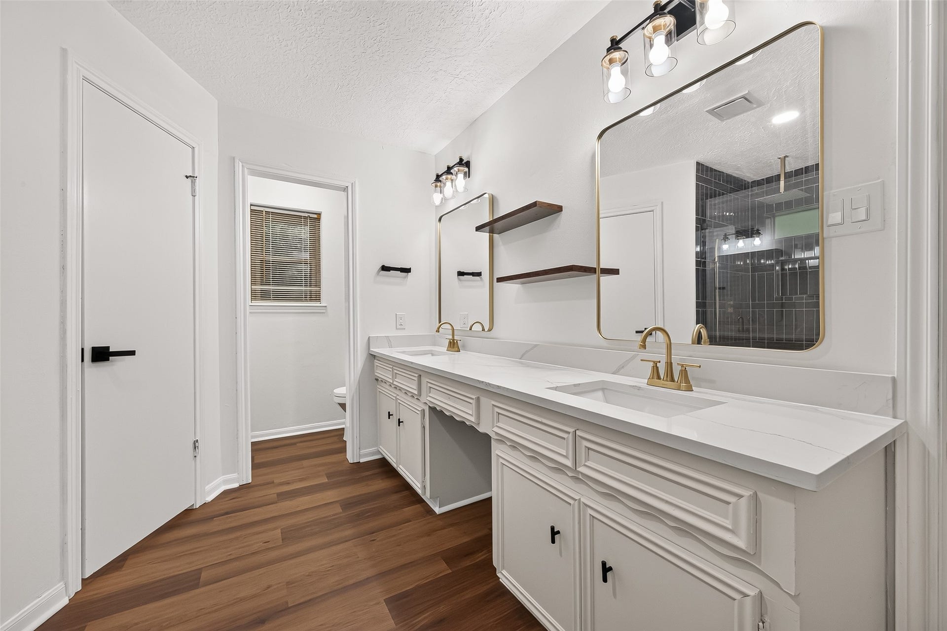 Beautiful dual-sink vanity with
elegant gold accents and modern
floating shelves
