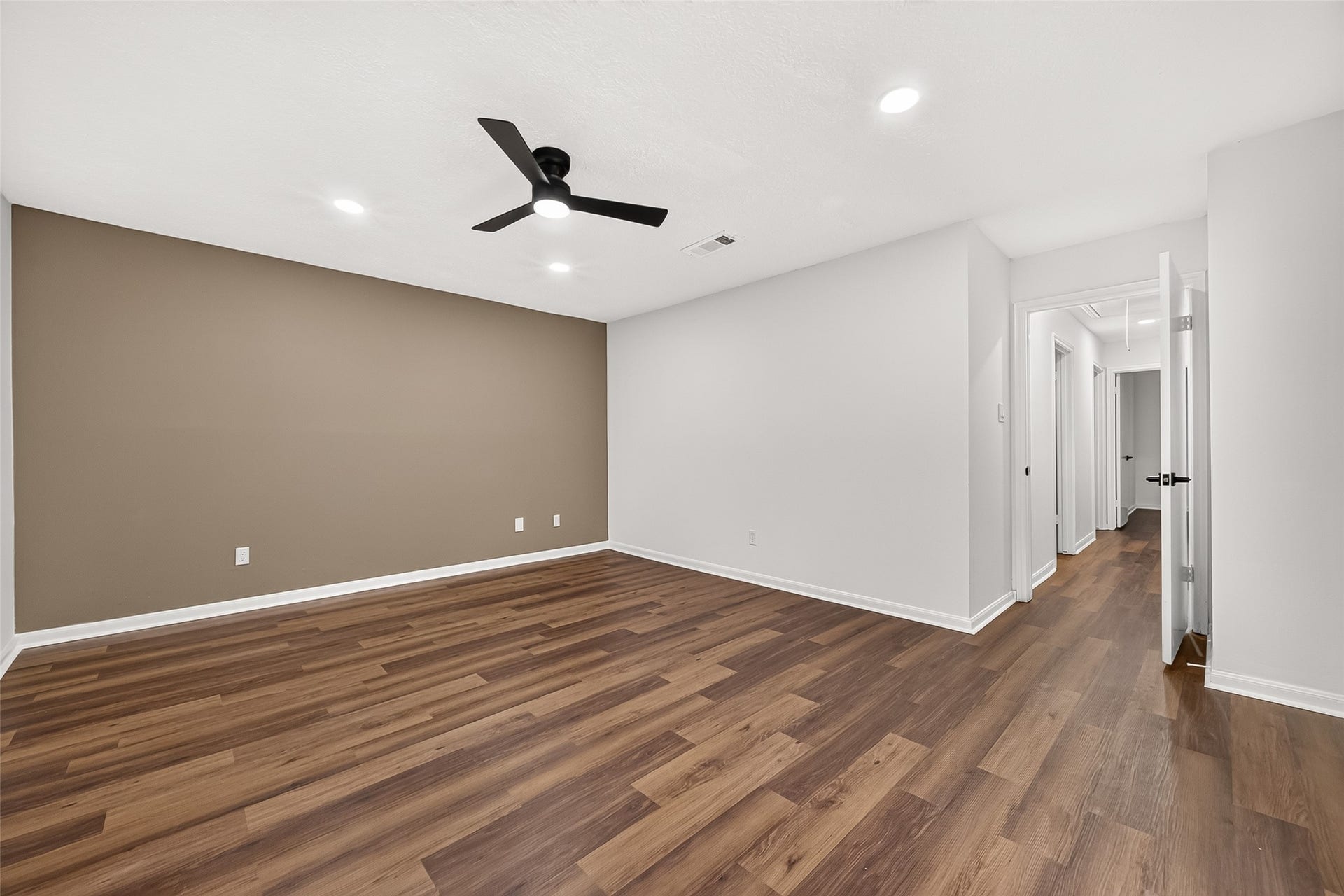 Beautiful primary bedroom
featuring a stylish accent wall and
modern finishes