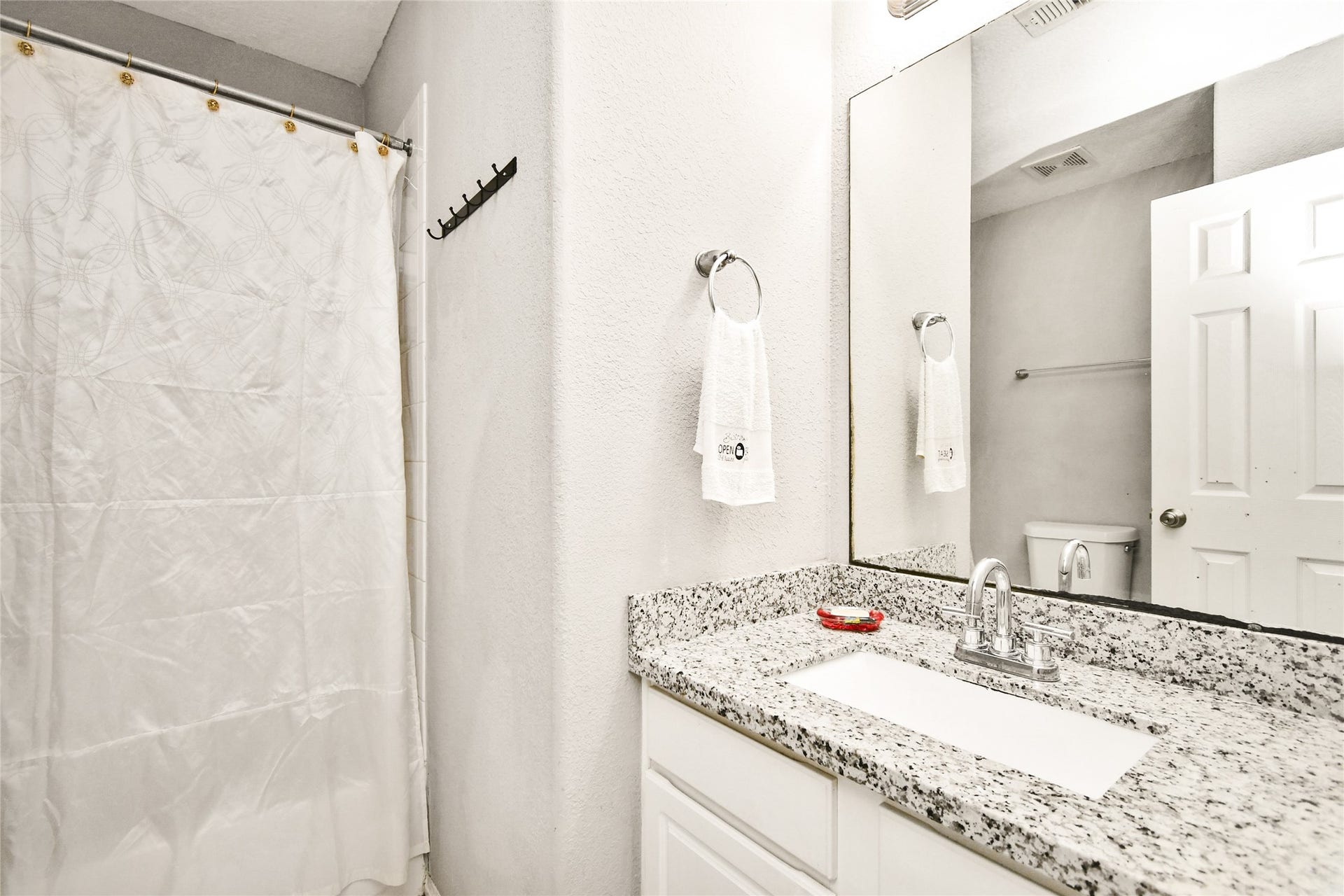 2319 Blue Reef Drive, Katy, TX 77449 Updated bathroom vanity with granite countertop, modern fixtures, and ample mirror space.
