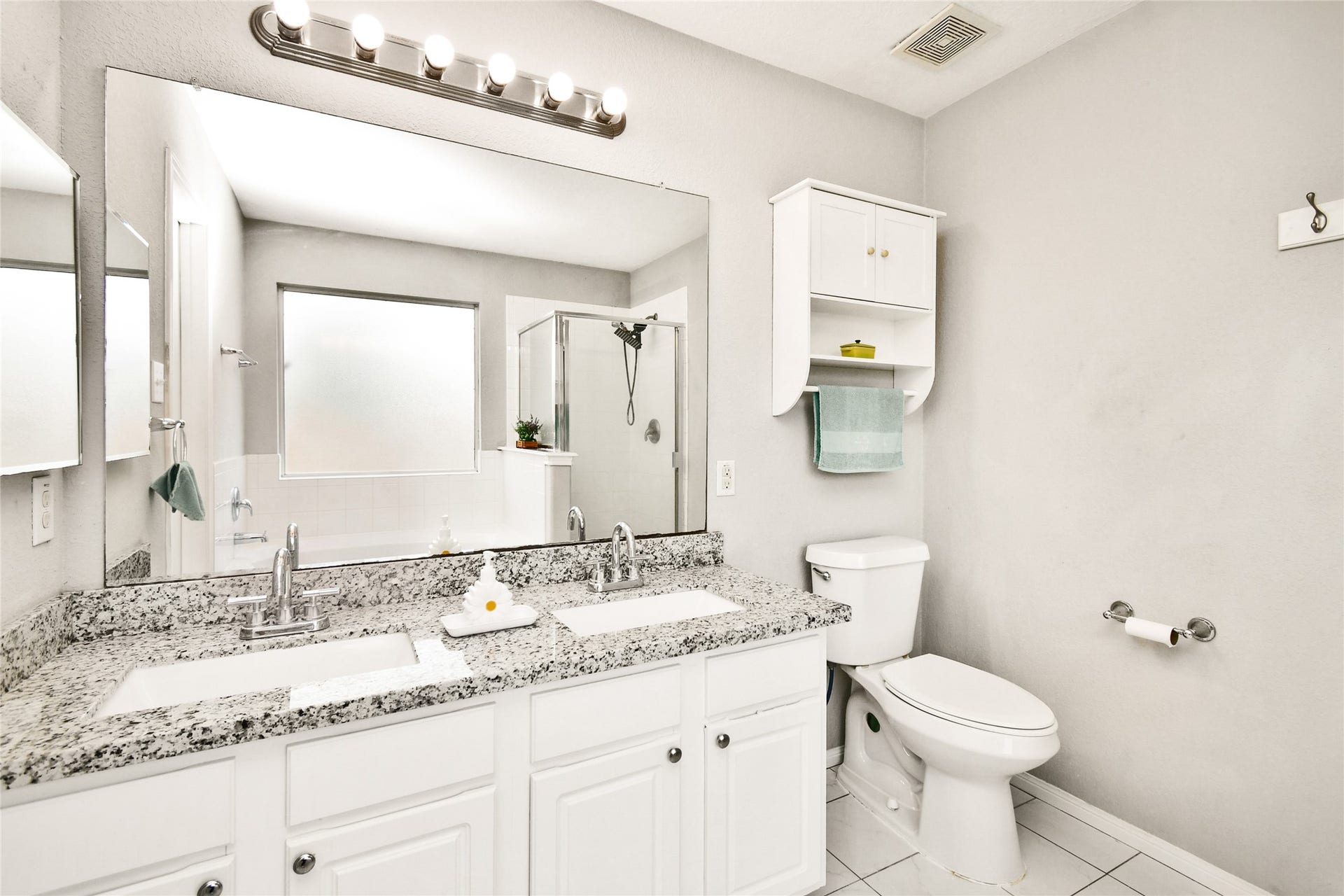 2319 Blue Reef Drive, Katy, TX 77449 Elegant en suite bathroom with a granite double vanity, a walk-in shower, and a soaking tub.