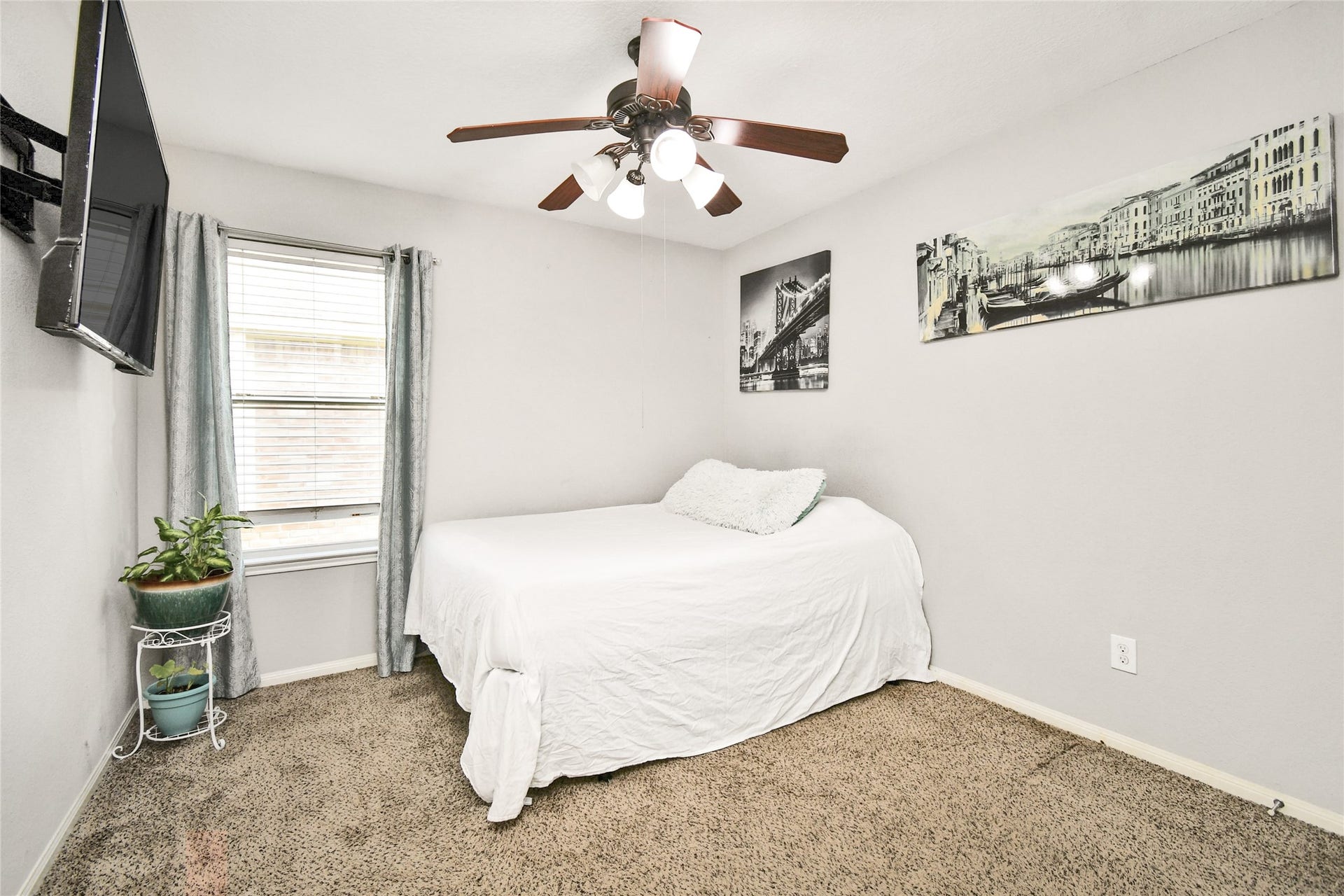 2319 Blue Reef Drive, Katy, TX 77449 Comfortable secondary bedroom with mounted TV, ceiling fan, and soft carpet flooring