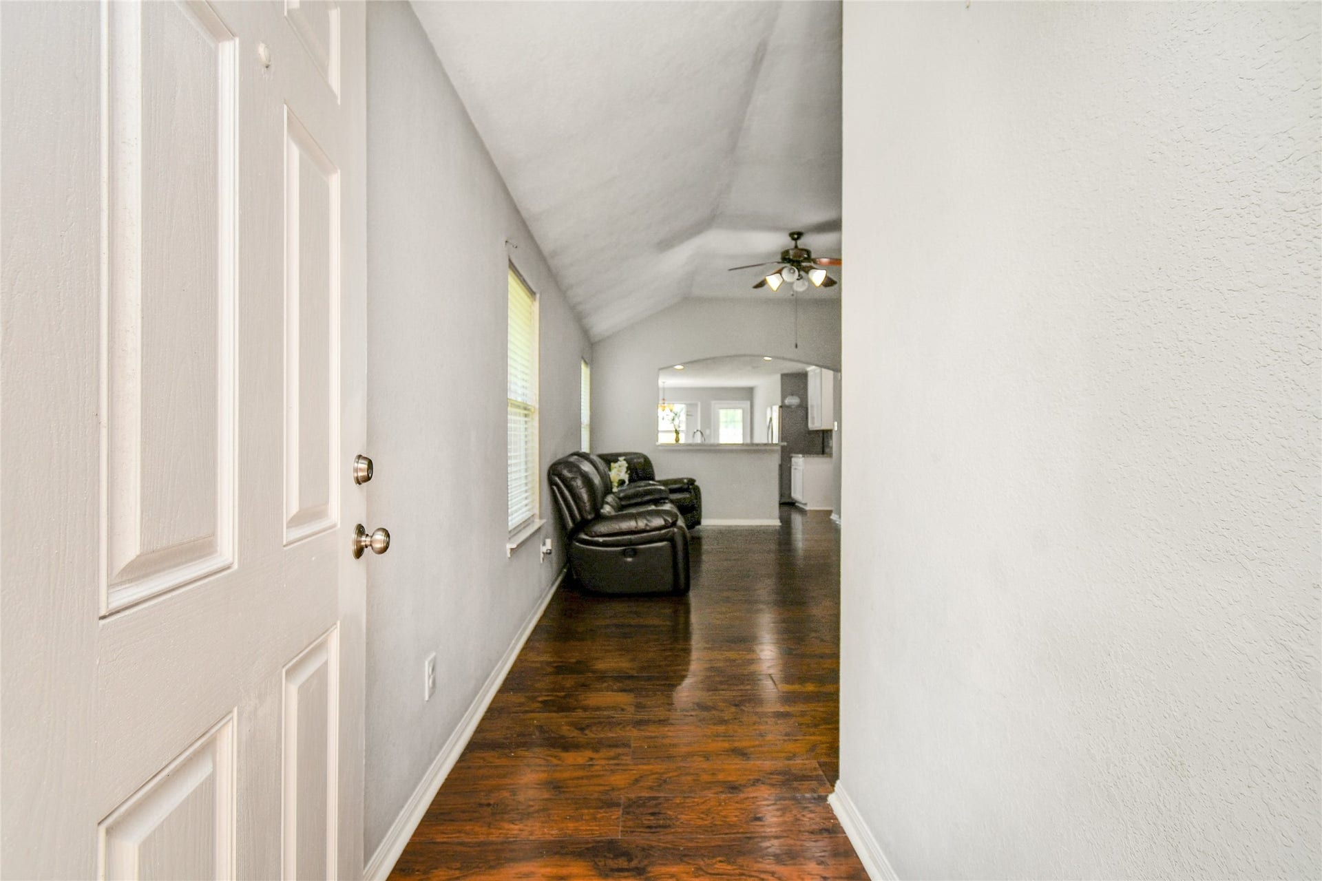 2319 Blue Reef Drive, Katy, TX 77449 Bright entryway with soaring vaulted ceilings and rich wood look vinyl flooring that flows into the open living area.