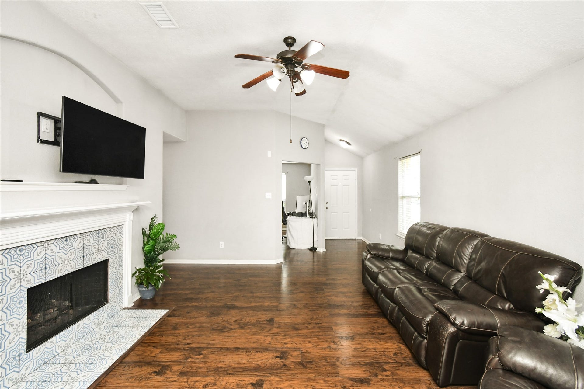 2319 Blue Reef Drive, Katy, TX 77449 Bright open living room with a cozy fireplace, ceiling fan, and easy flow into the kitchen and front entry.