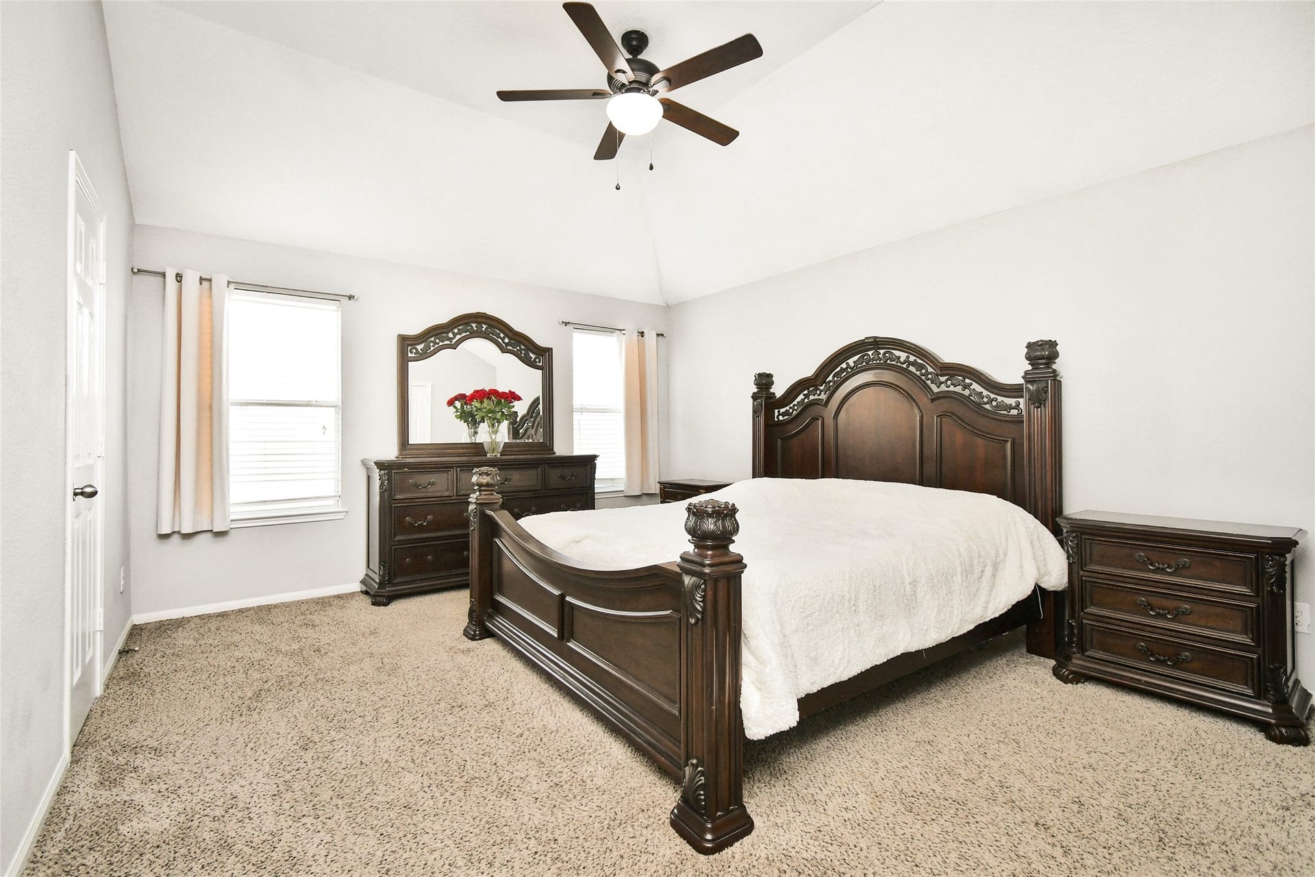 2319 Blue Reef Drive, Katy, TX 77449 Spacious primary bedroom featuring vaulted ceilings, a ceiling fan, and plenty of natural light from dual windows.