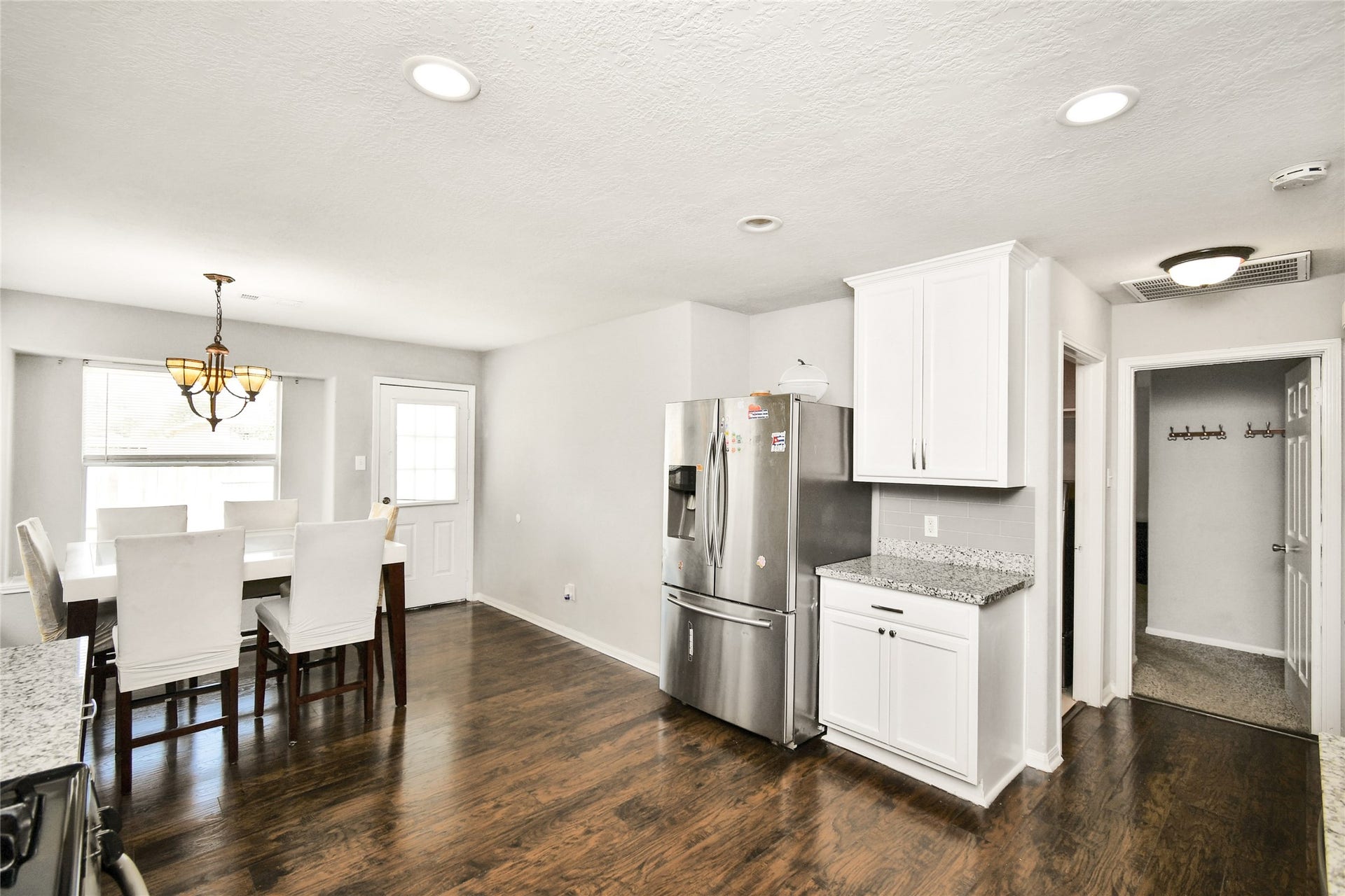 2319 Blue Reef Drive, Katy, TX 77449 Functional kitchen layout with stainless steel refrigerator, ample cabinet storage, and access to the back entry.