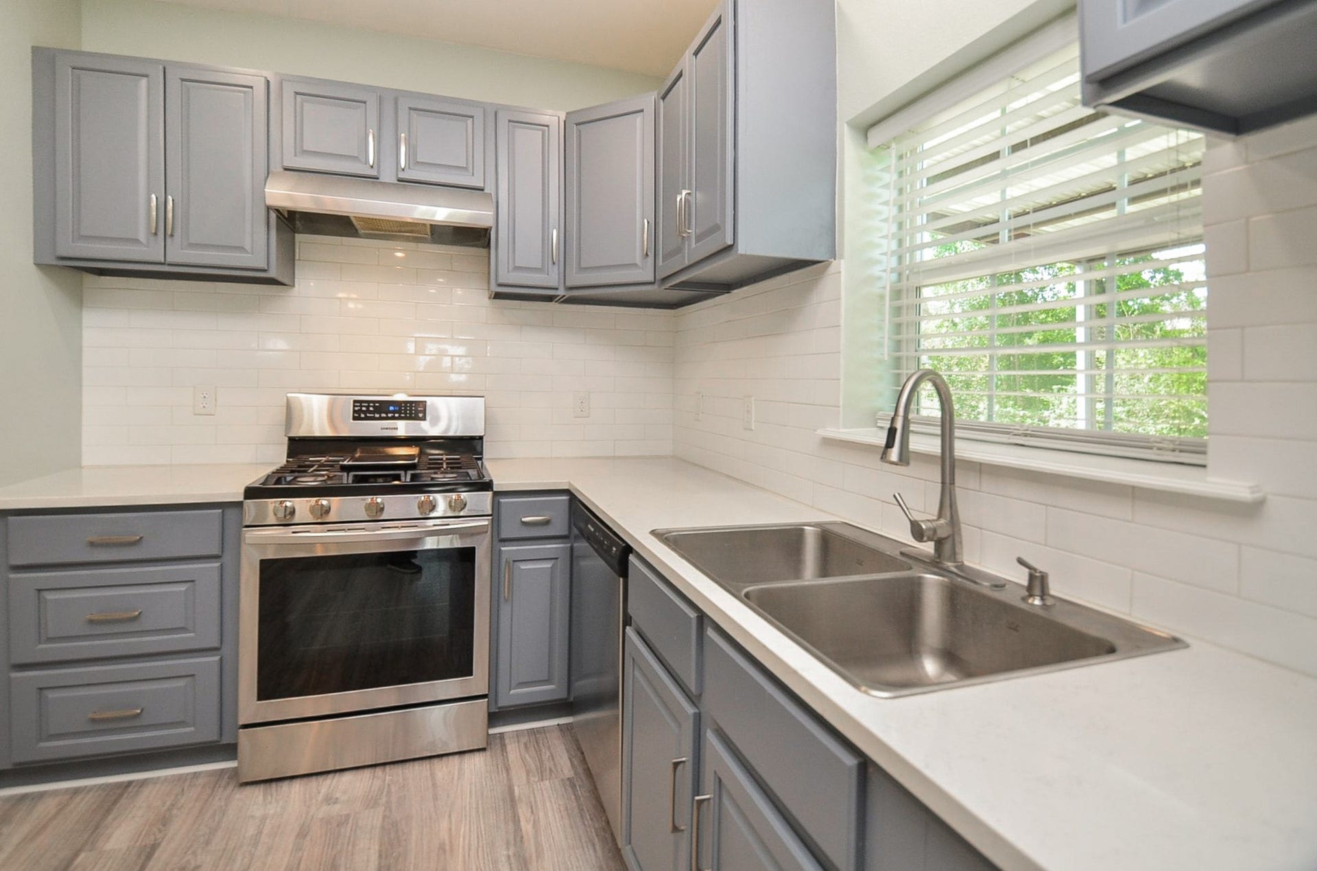 Lovely pewter toned cabinetry lines wall and counter space in this easily navigated kitchen.