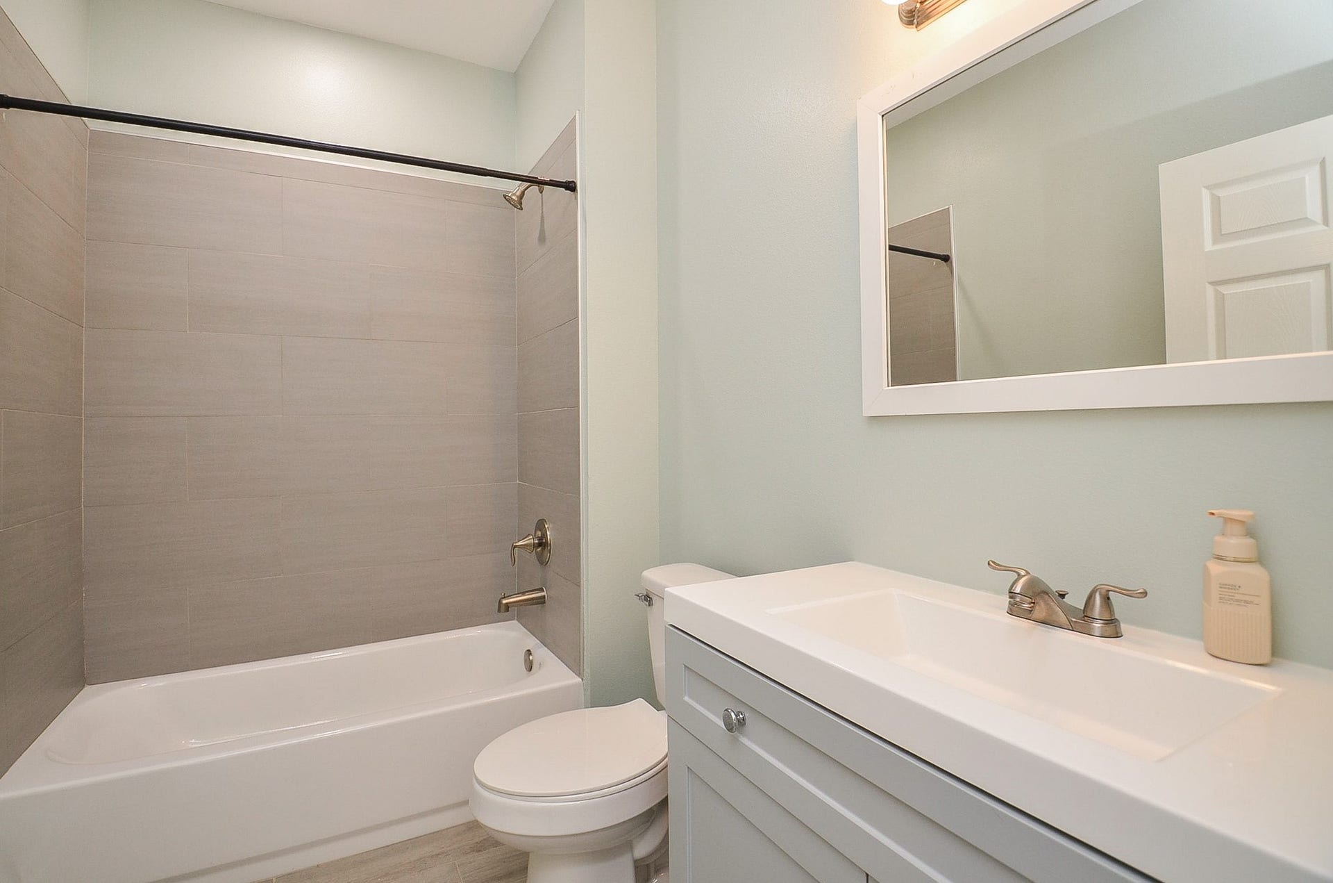 A sleek secondary bath offers the same comforts as its primary, with convenient combined shower/bathtub for personal options.