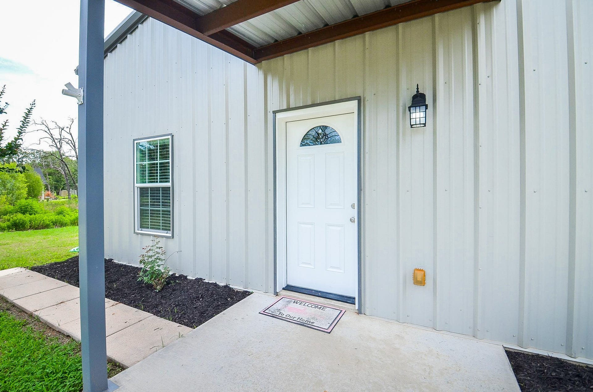 The modest covered front entry also offers rich planting beds for your green thumb!