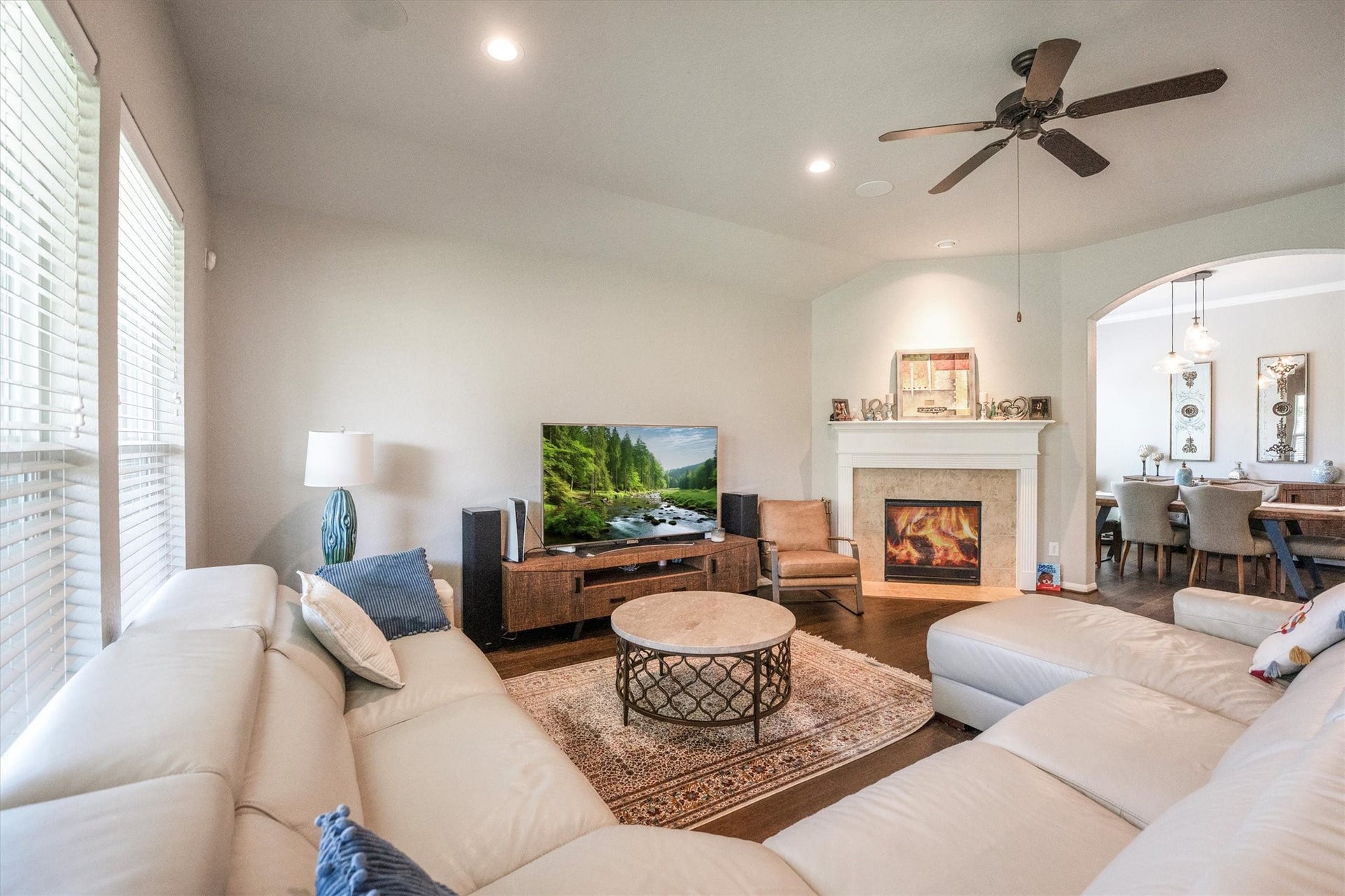 25227 Hawthorne Blossom Drive, Spring, TX 77389 Spacious living room with a cozy fireplace, modern furnishings, and abundant natural light, seamlessly connected to the dining area.