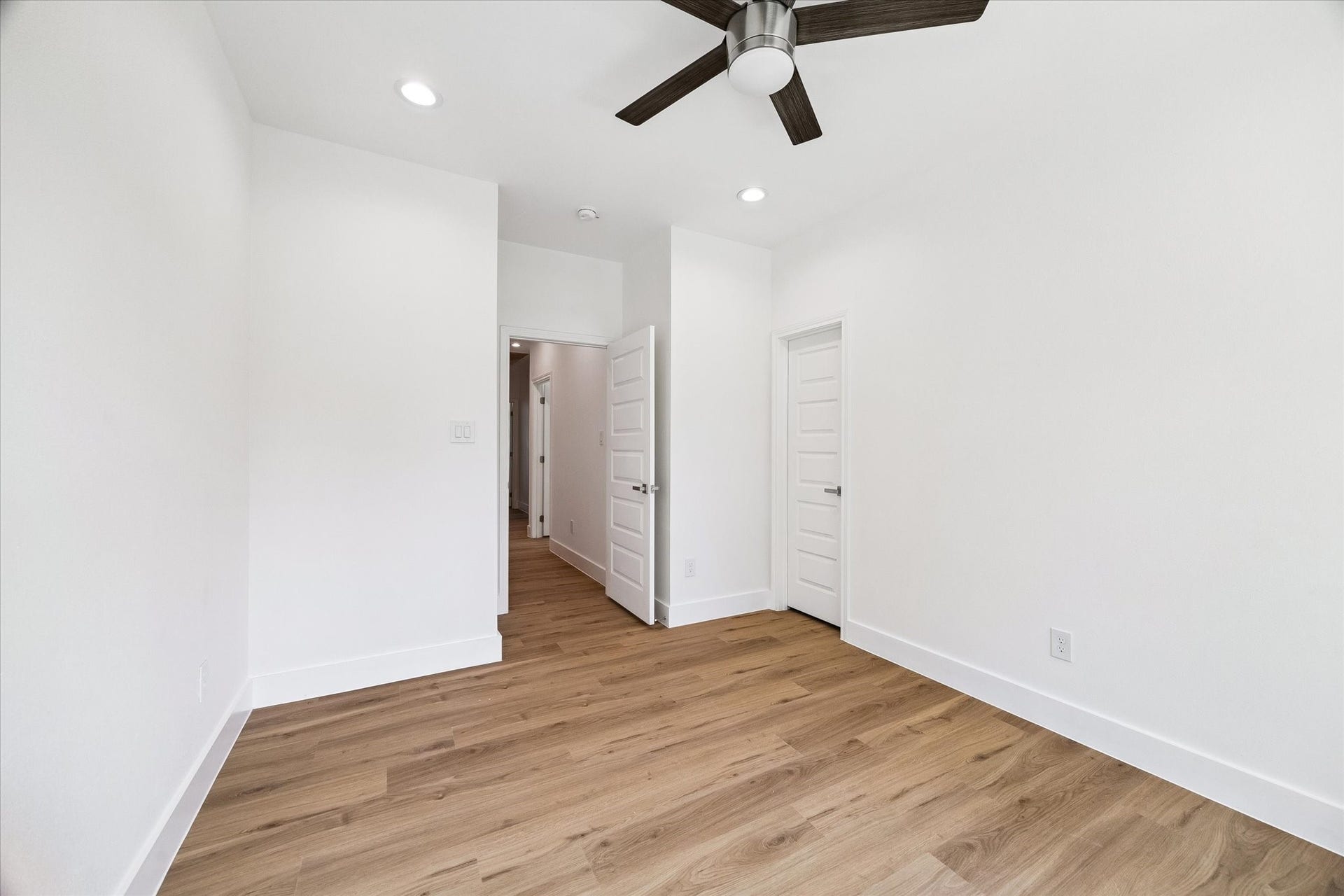 5310 Salina Street, Houston, TX 77026 Another angle of the bedroom highlights its comfortable proportions and clean contemporary styling. Warm wood-look flooring runs throughout, while recessed lighting and a modern ceiling fan add function and visual appeal. Neutral walls create a versatile backdrop for furnishings, and nearby doors provide convenient access to the hallway and closet space.