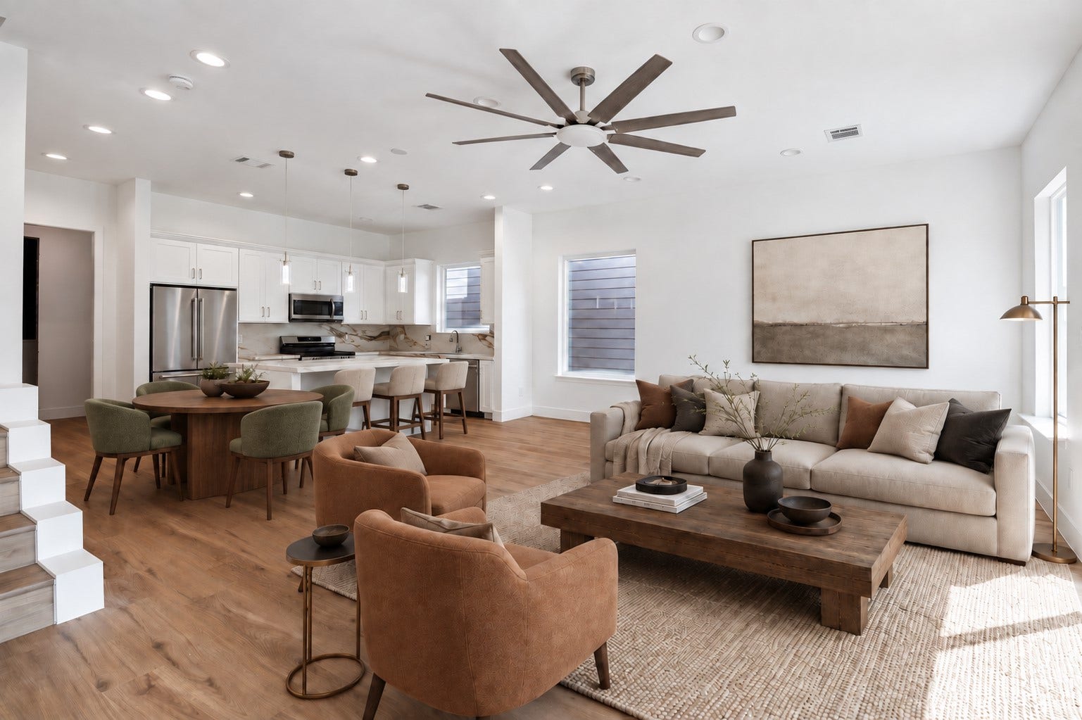 5310 Salina Street, Houston, TX 77026 From this angle, the open layout between the living area and kitchen truly shines. A spacious footprint allows plenty of room for comfortable seating and dining arrangements, while the large ceiling fan adds style and everyday comfort. Natural light pours in through expansive windows and glass doors, highlighting the warm flooring and crisp neutral walls. The kitchen remains visually connected for easy conversation and entertaining. This photo has been virtually staged for visual reference.