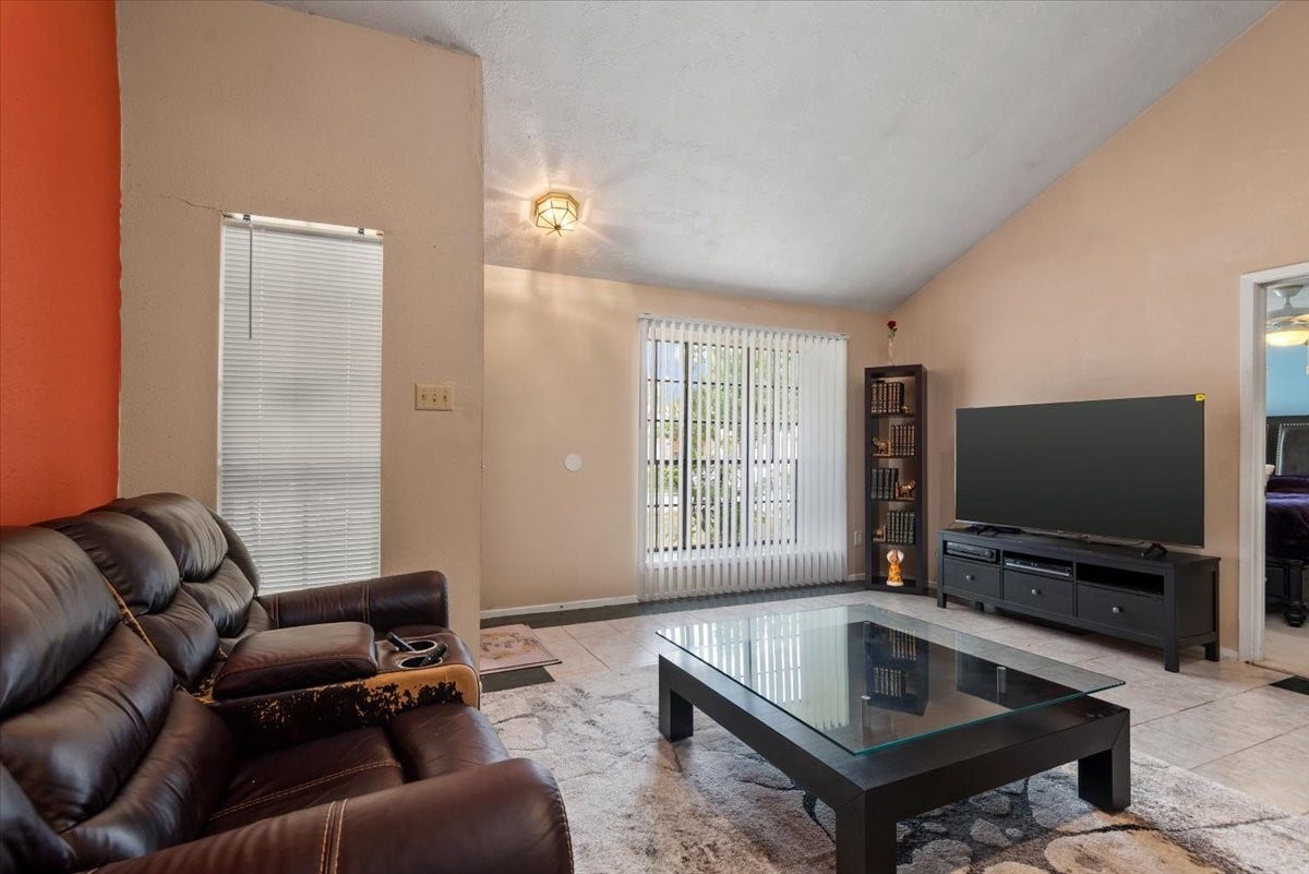 9522 Wellsworth Drive, Houston, TX 77083 Bright living room with vaulted ceiling, large windows, and ample seating space