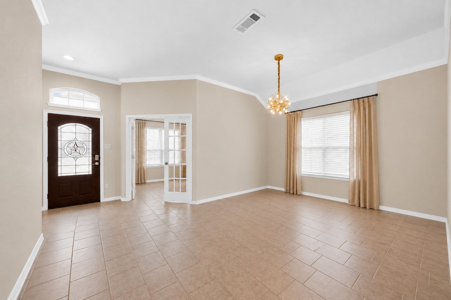 1902 Willow Ridge Ln, Fulshear, TX 77423 Furniture and personal dcor have been digitally removed to showcase the dining rooms layout, tile flooring, crown molding, and natural light. French doors connect to an adjacent room near the front entry.