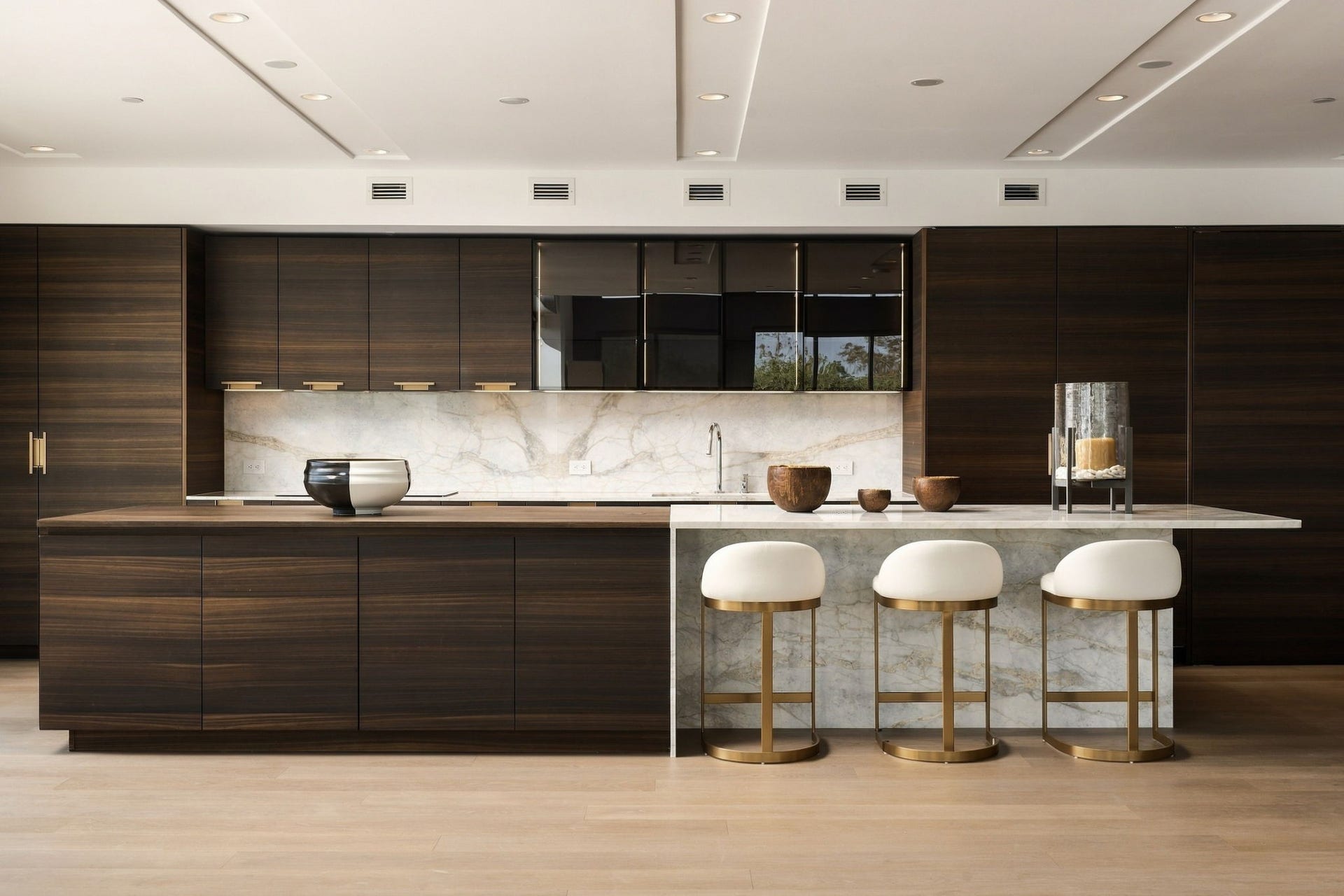 Wrought from rich wood and stunning marble, the primary kitchen's massive center island provides dedicated space for serving and casual dining.