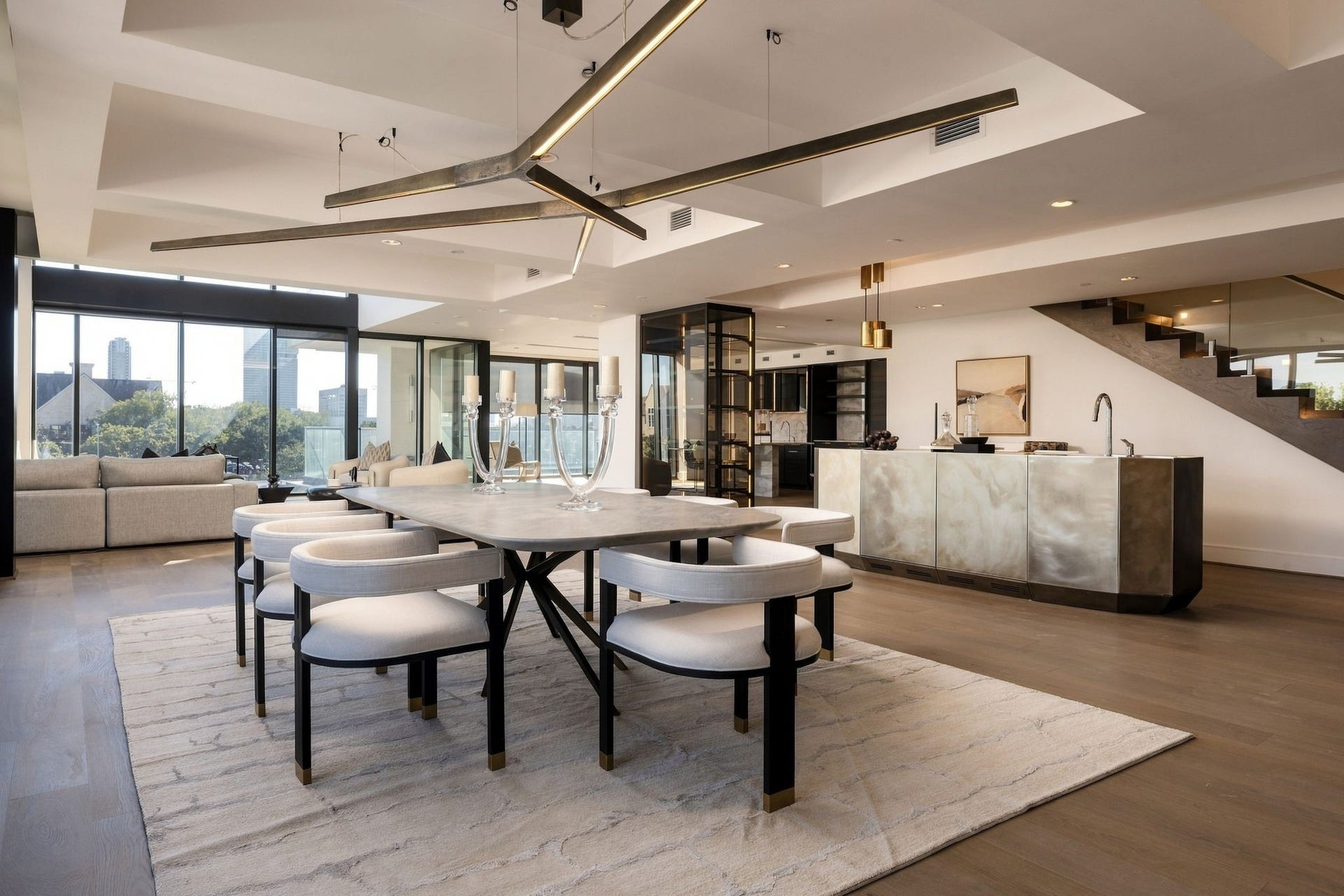 The impressive dining room is topped with tray ceilings and a sculptural Henge Starlight brass chandelier.