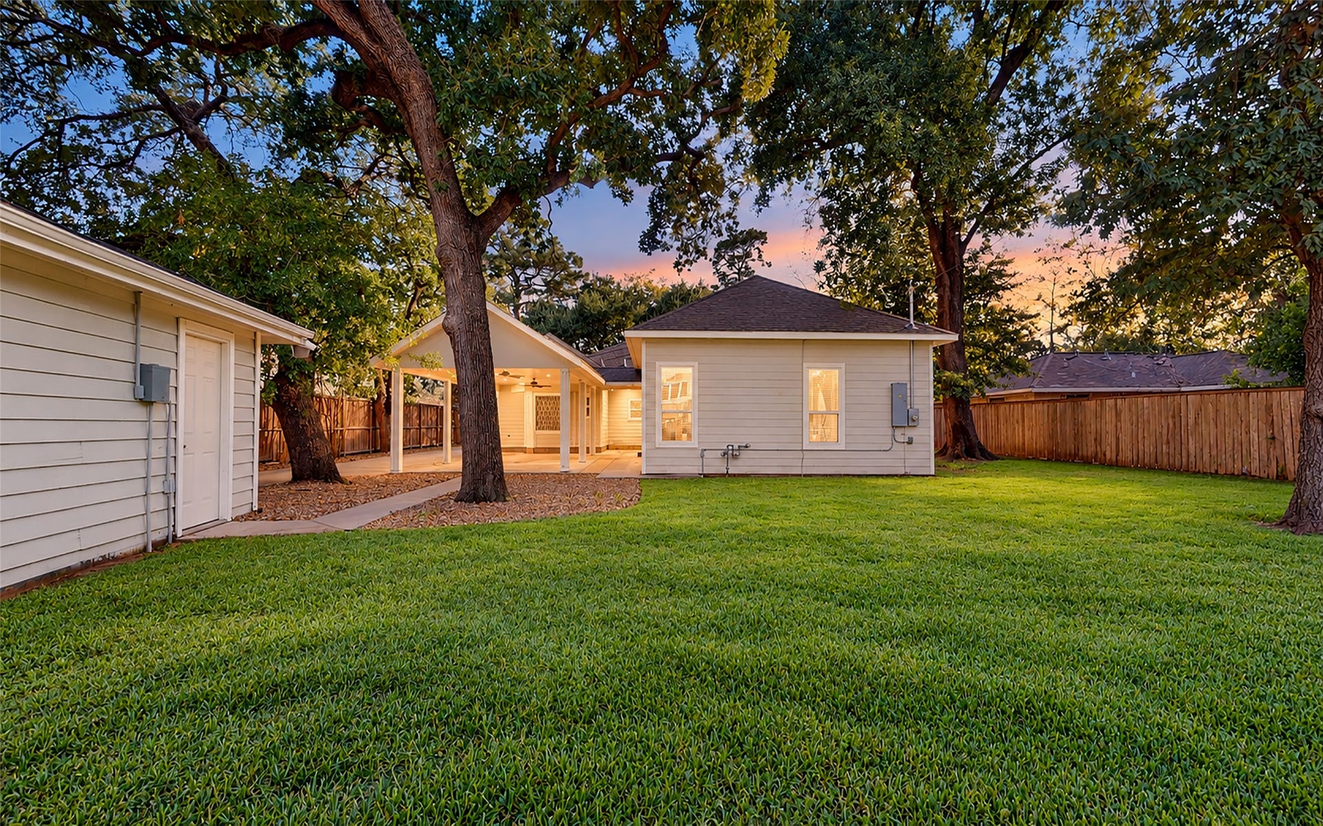 702 W 41st Street, Houston, TX 77018 As the sun sets, this beautiful backyard offers a peaceful retreat with towering shade trees, a lush green lawn, plenty of privacy and a covered outdoor area. There's room for backyard games, weekend gatherings or simply enjoying a quiet evening at home, while a full sprinkler system helps keep the lawn and landscaping looking their best.