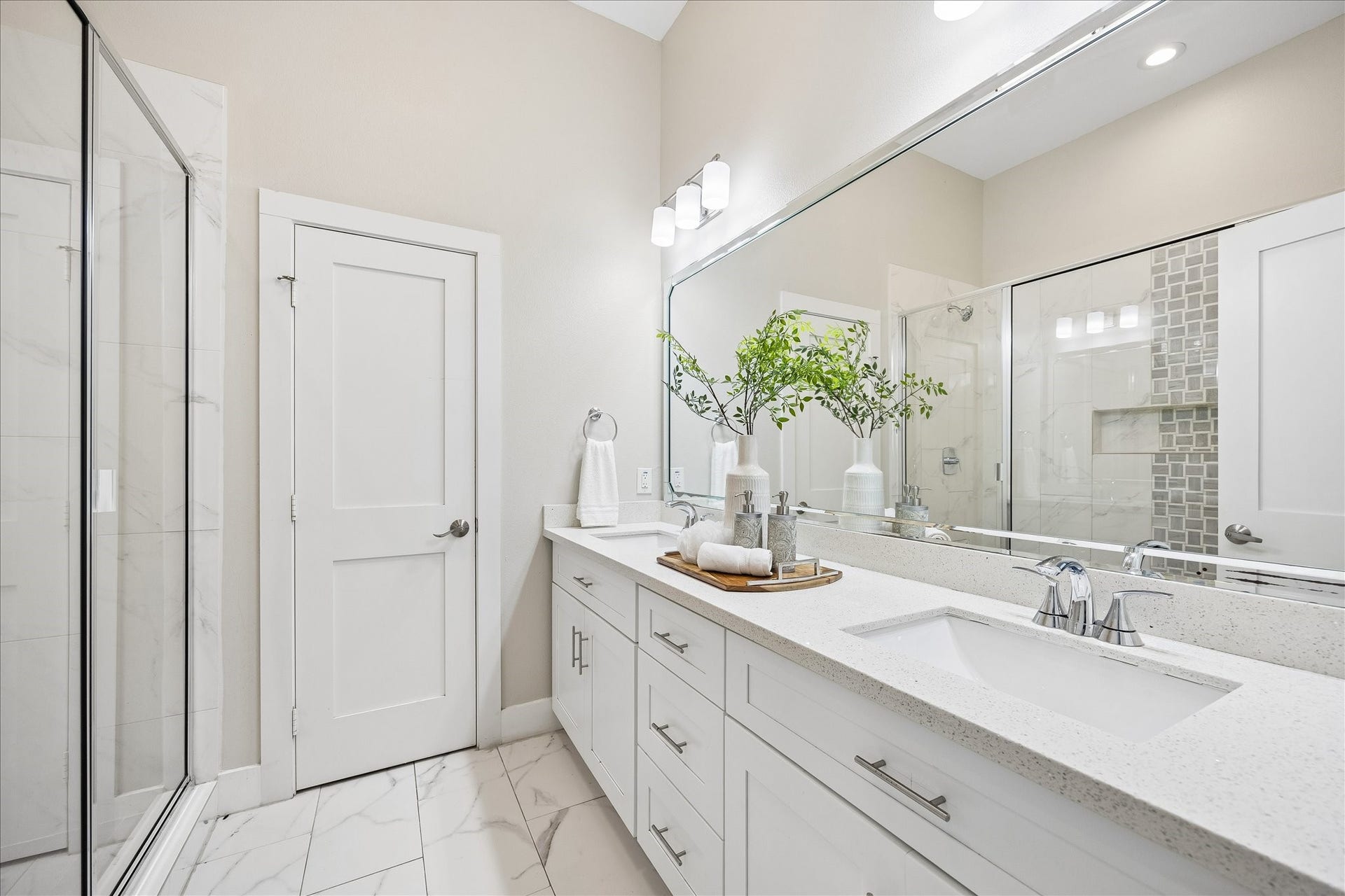 702 W 41st Street, Houston, TX 77018 Guests will enjoy a little privacy and a lot of pampering in this beautifully finished ensuite. A long vanity with dual sinks, ample counter space and plenty of storage makes busy mornings easier, while a spacious glass-enclosed shower offers a refreshing start to the day.