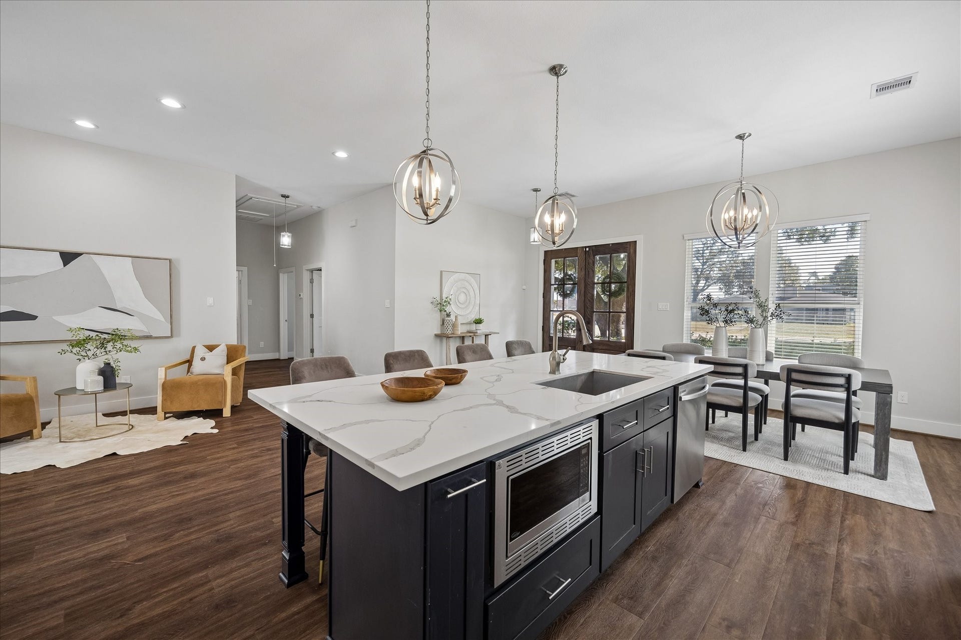 702 W 41st Street, Houston, TX 77018 There's no shortage of workspace here! The oversized island offers additional prep and serving space, convenient bar seating, a prep sink and built-in microwave. Stylish pendant lights complete the look, while the open layout keeps the dining and living areas just steps away.
