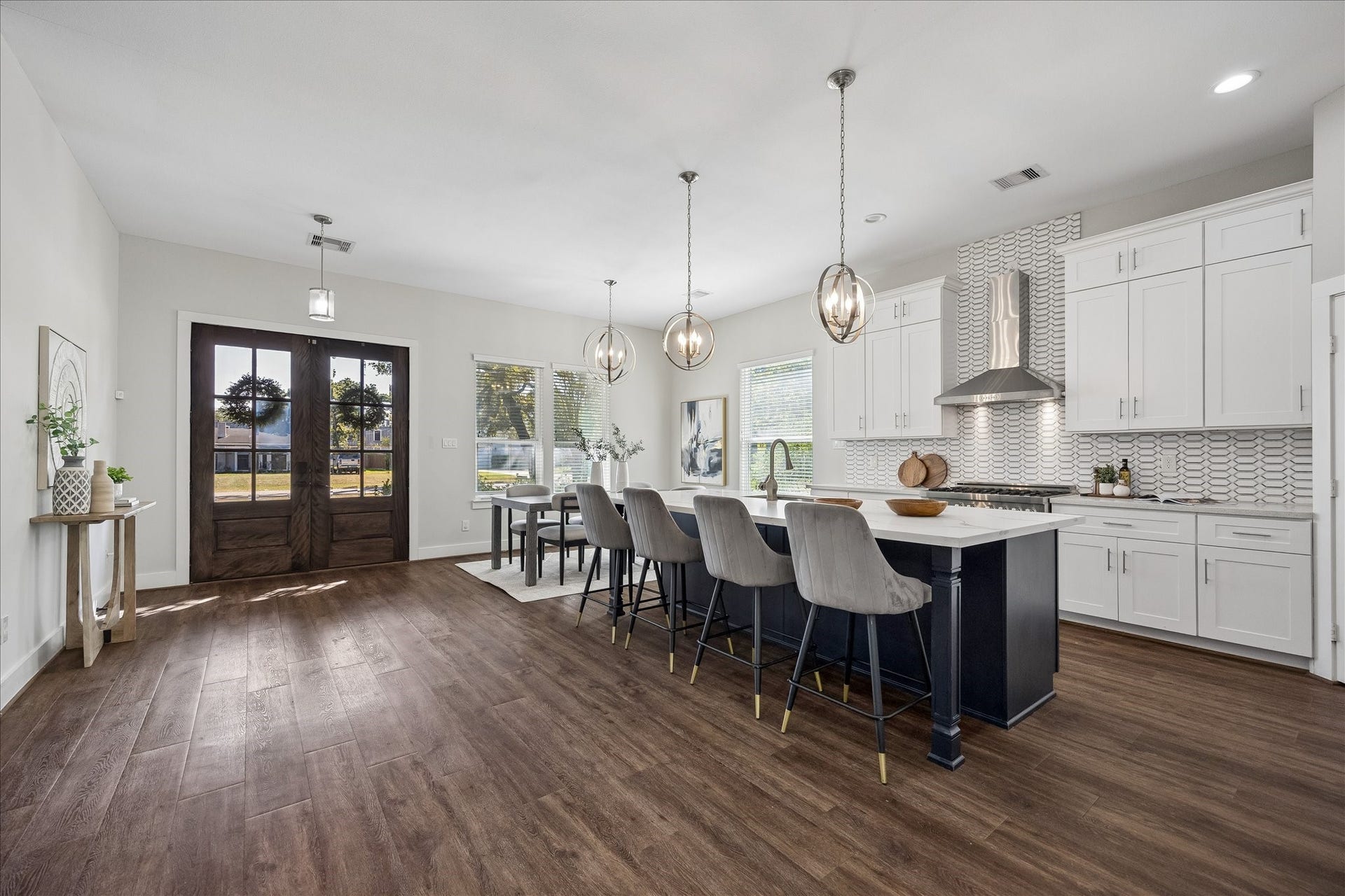 702 W 41st Street, Houston, TX 77018 From quick weekday breakfasts to big holiday gatherings, this kitchen is ready for it all! Crisp white cabinetry, a spacious contrasting island with bar seating, stylish pendant lights, stainless steel appliances and sleek tile backsplash bringing plenty of style and charm right into the heart of the home.
