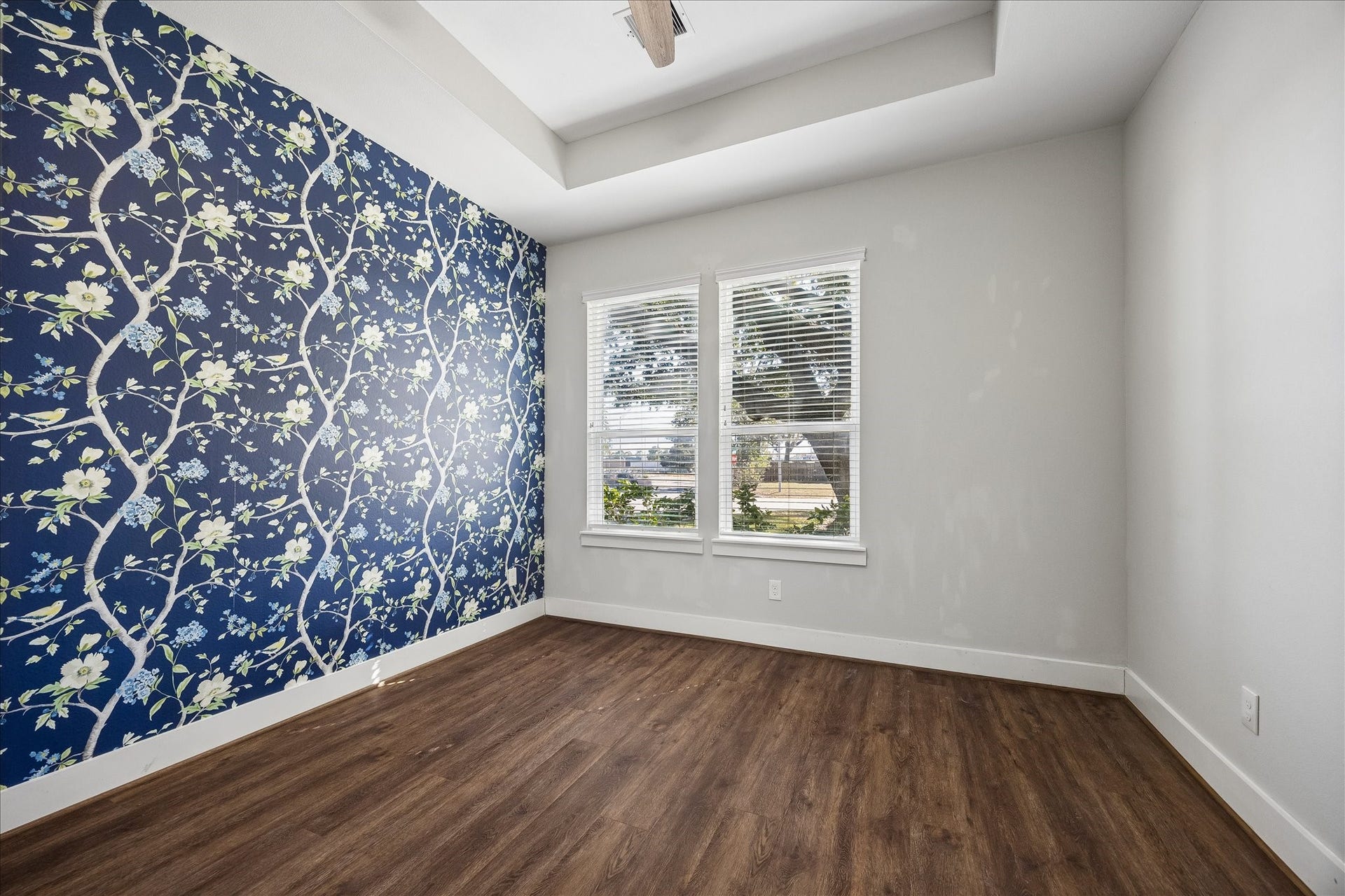 702 W 41st Street, Houston, TX 77018 Who says a guest bedroom can't have a little personality? Gorgeous custom wallpaper creates a beautiful accent wall, while a tray ceiling, large windows and updated luxury vinyl tile flooring make this a bright, inviting retreat.