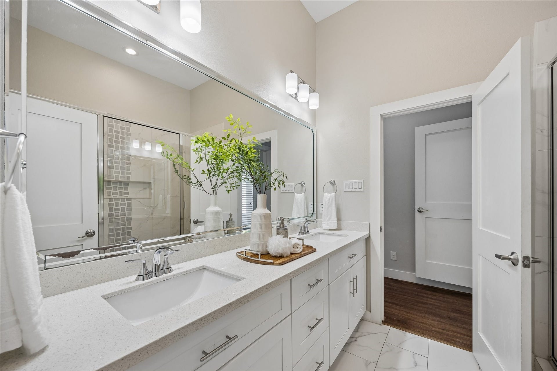 702 W 41st Street, Houston, TX 77018 No need to compete for mirror space here. Dual sinks, an expansive vanity, stylish lighting and abundant cabinetry give everyone room to get ready, while the soft neutral finishes create a bright, relaxing atmosphere.