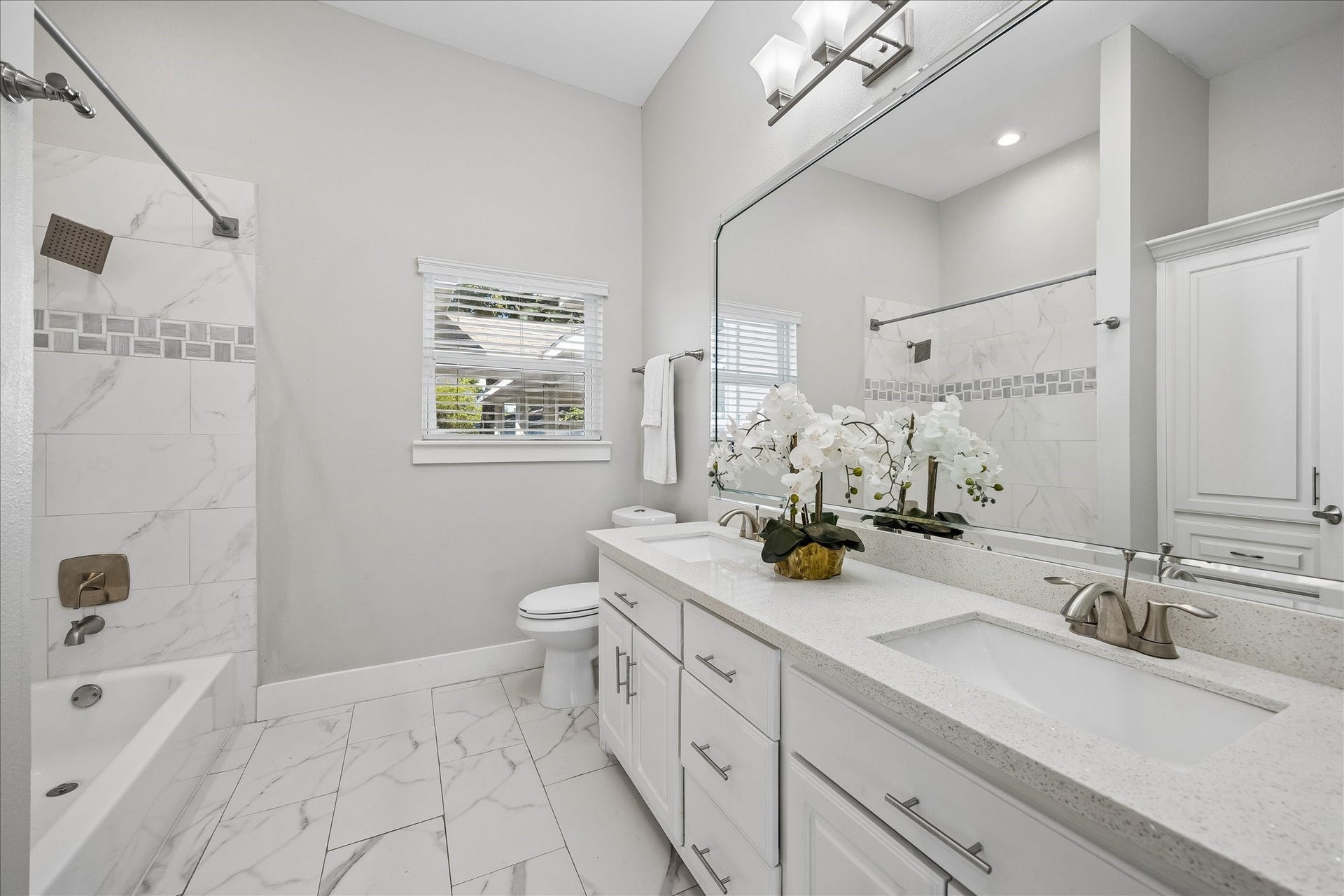 702 W 41st Street, Houston, TX 77018 With three full bathrooms, there's room for everyone to get ready. This spacious hall bathroom features dual sinks, plenty of counter space and storage plus a tub and shower combination, all wrapped up in stylish neutral finishes.