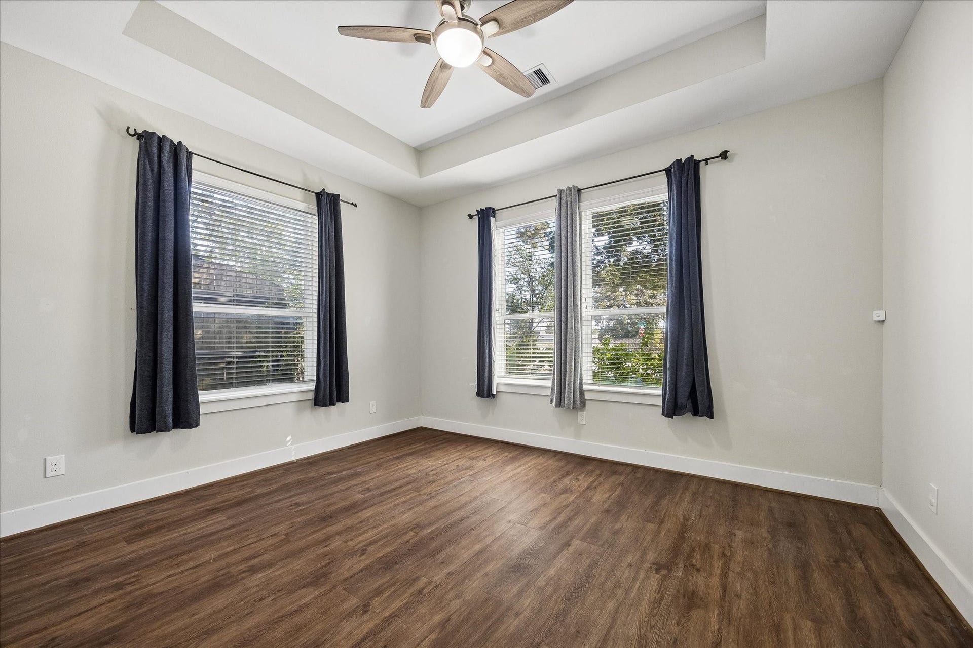 702 W 41st Street, Houston, TX 77018 Your guests will feel right at home in this bright, inviting bedroom with a beautiful tray ceiling, cooling ceiling fan and updated luxury vinyl tile flooring. Large windows welcome plenty of natural light, while a spacious closet and nearby full bathroom make it easy to unpack and stay awhile.