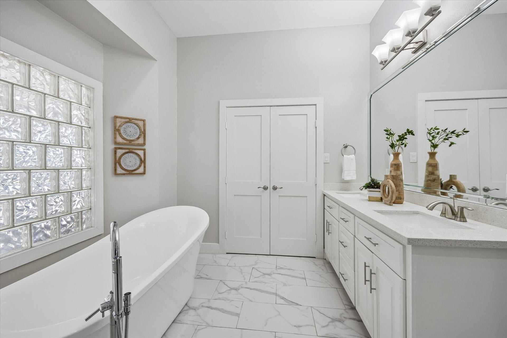 702 W 41st Street, Houston, TX 77018 Enjoy a daily dose of luxury in this spa-like ensuite, where a freestanding soaking tub, walk-in shower, long dual sink vanity and soft neutral finishes create a calm, polished feel. Abundant storage keeps everything neatly tucked away, making this beautiful retreat as practical as it is relaxing.
