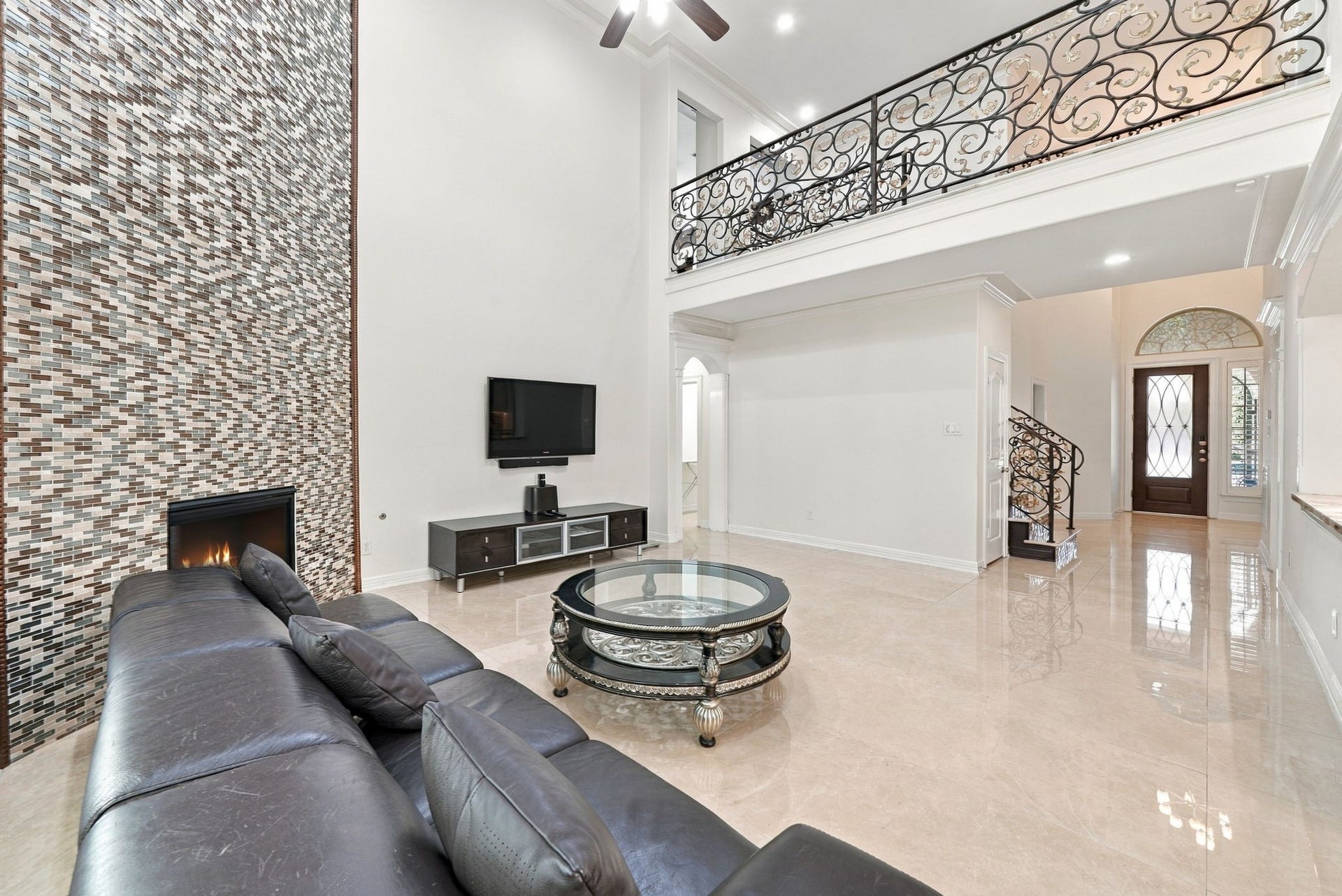 5411 Oban Terrace Lane, Sugar Land, TX 77479 The decorative upstairs railing and polished tile flooring complement the living room's impressive design, creating a sophisticated space with character at every turn.