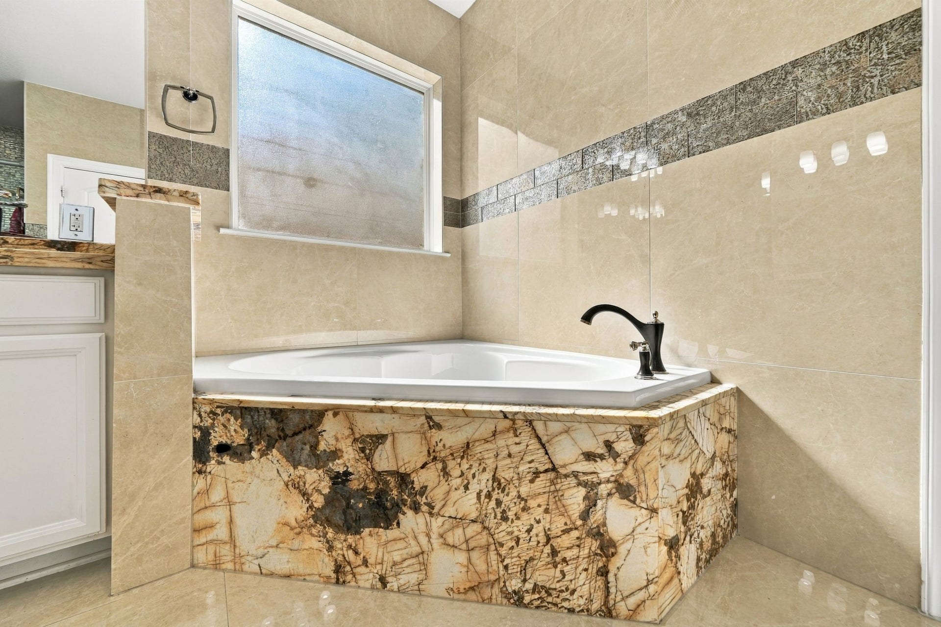 5411 Oban Terrace Lane, Sugar Land, TX 77479 Imagine coming home to a warm, relaxing bath in this beautiful soaking tub, surrounded by rich stone finishes that make every moment feel special.