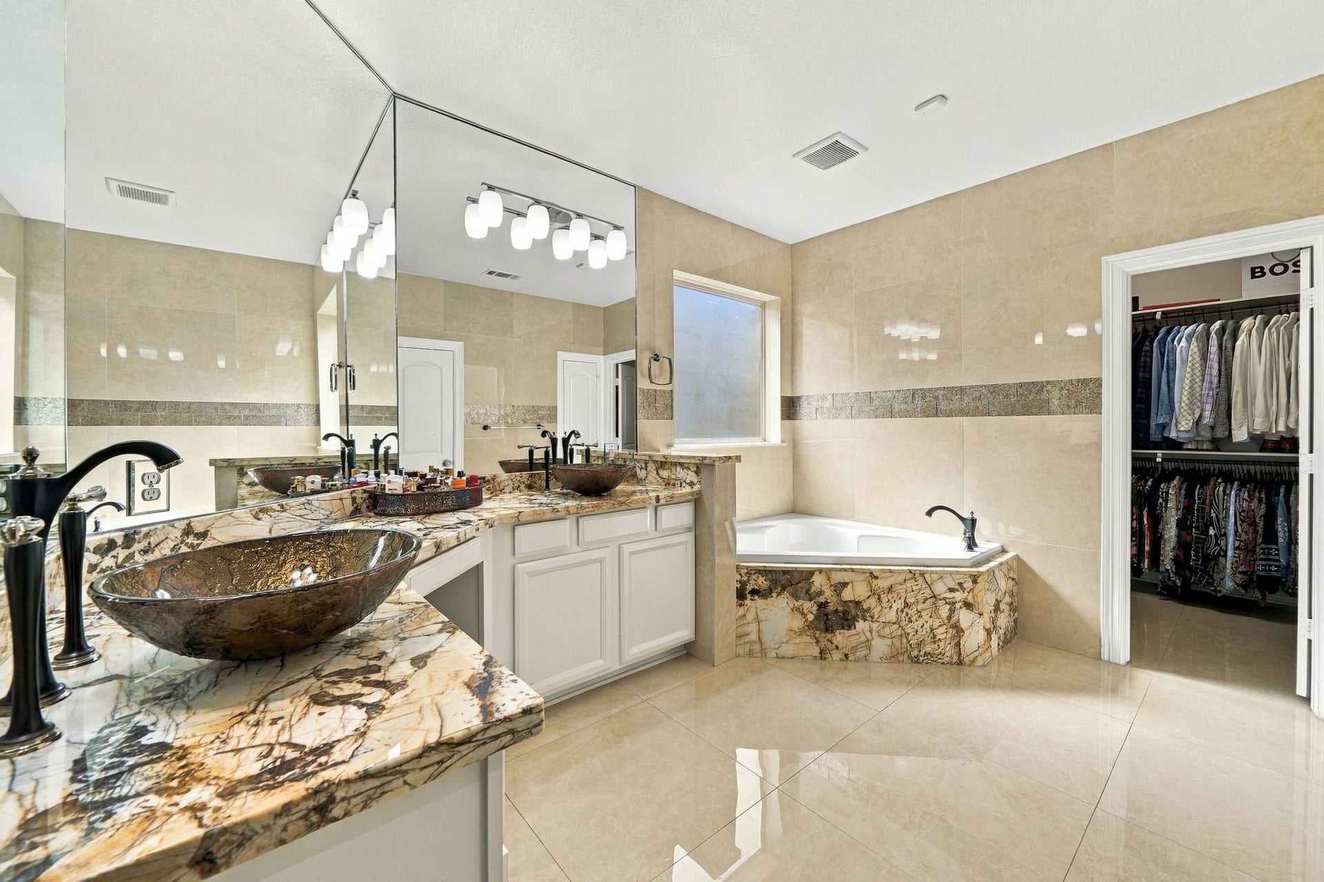 5411 Oban Terrace Lane, Sugar Land, TX 77479 Enjoy the luxury of a primary bath featuring separate upgraded vanities, a corner soaking tub, and direct access to a walk-in closet.