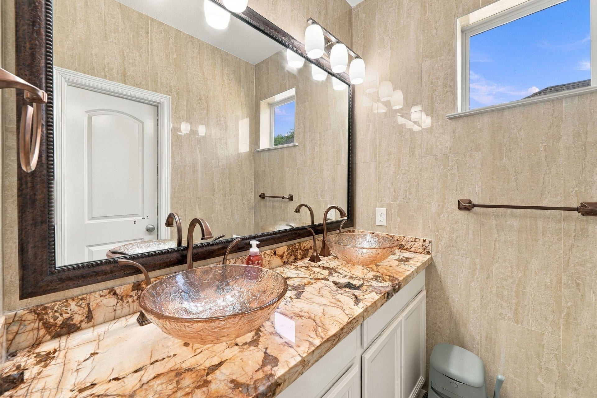 5411 Oban Terrace Lane, Sugar Land, TX 77479 This bathroom combines elegant vessel sinks, striking stone countertops, and a double vanity that makes getting ready each day a little easier.