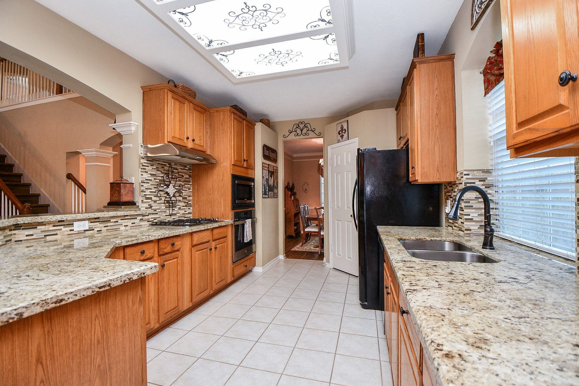A kitchen where everyday functionality meets thoughtful updates! Remodeled in 2023, this inviting space offers granite countertops, abundant cabinetry and a convenient connection to the formal dining room, making everything from weeknight meals to holiday entertaining easier.