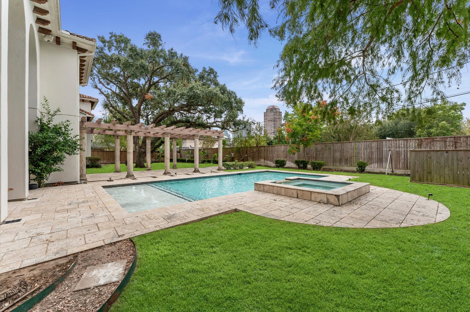5135 Longmont Drive, Houston, TX 77056 The rear elevation showcases the estate's exceptional outdoor living amenities, including the covered loggia, open-air patios, expansive pergola, saline pool and raised spa, and elevated side deck.