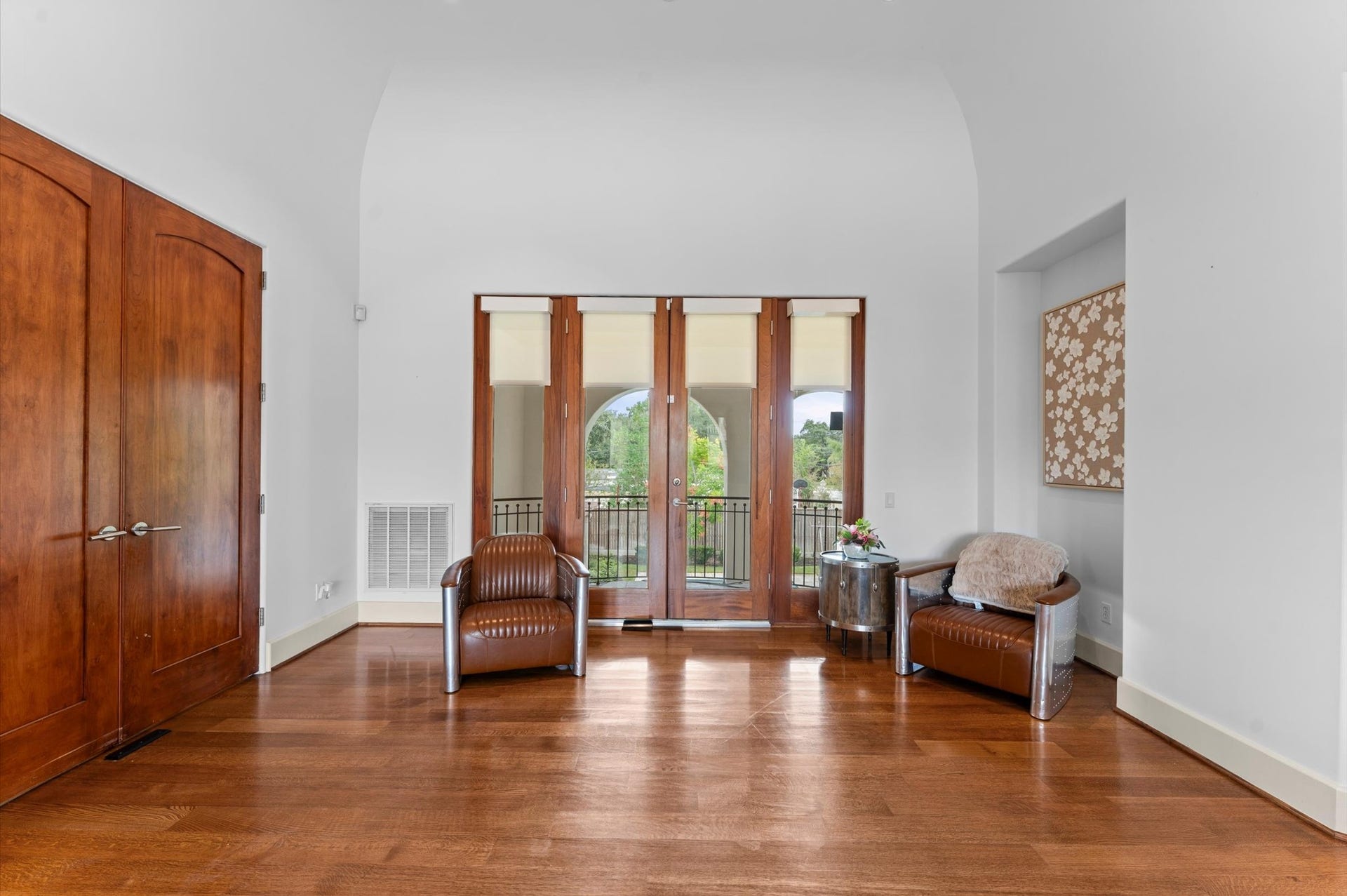 5135 Longmont Drive, Houston, TX 77056 Solid mahogany doors open to a secluded primary suite in its own private wing, featuring an inviting sitting area and a private balcony overlooking the pool.