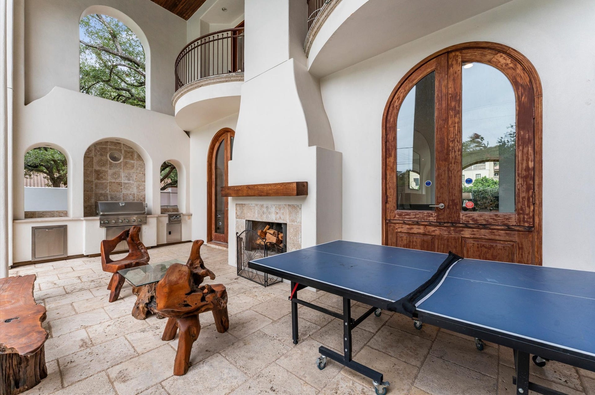 5135 Longmont Drive, Houston, TX 77056 The covered rear loggia creates an inviting outdoor living room, complete with a raised fireplace, built-in gas grill, and separate burner, ideal for year-round entertaining.